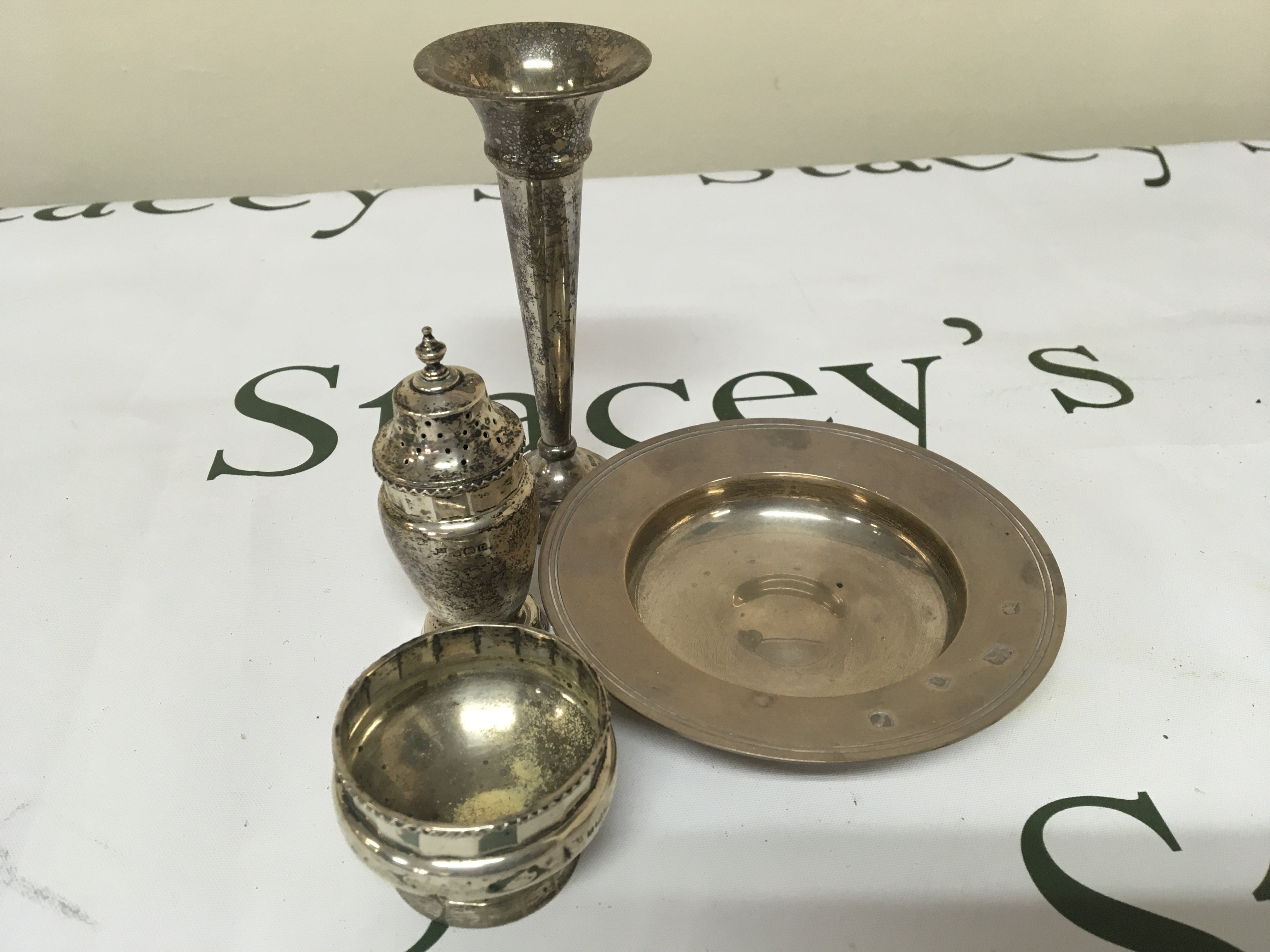 A small silver dish condiments and a small , silver vase.