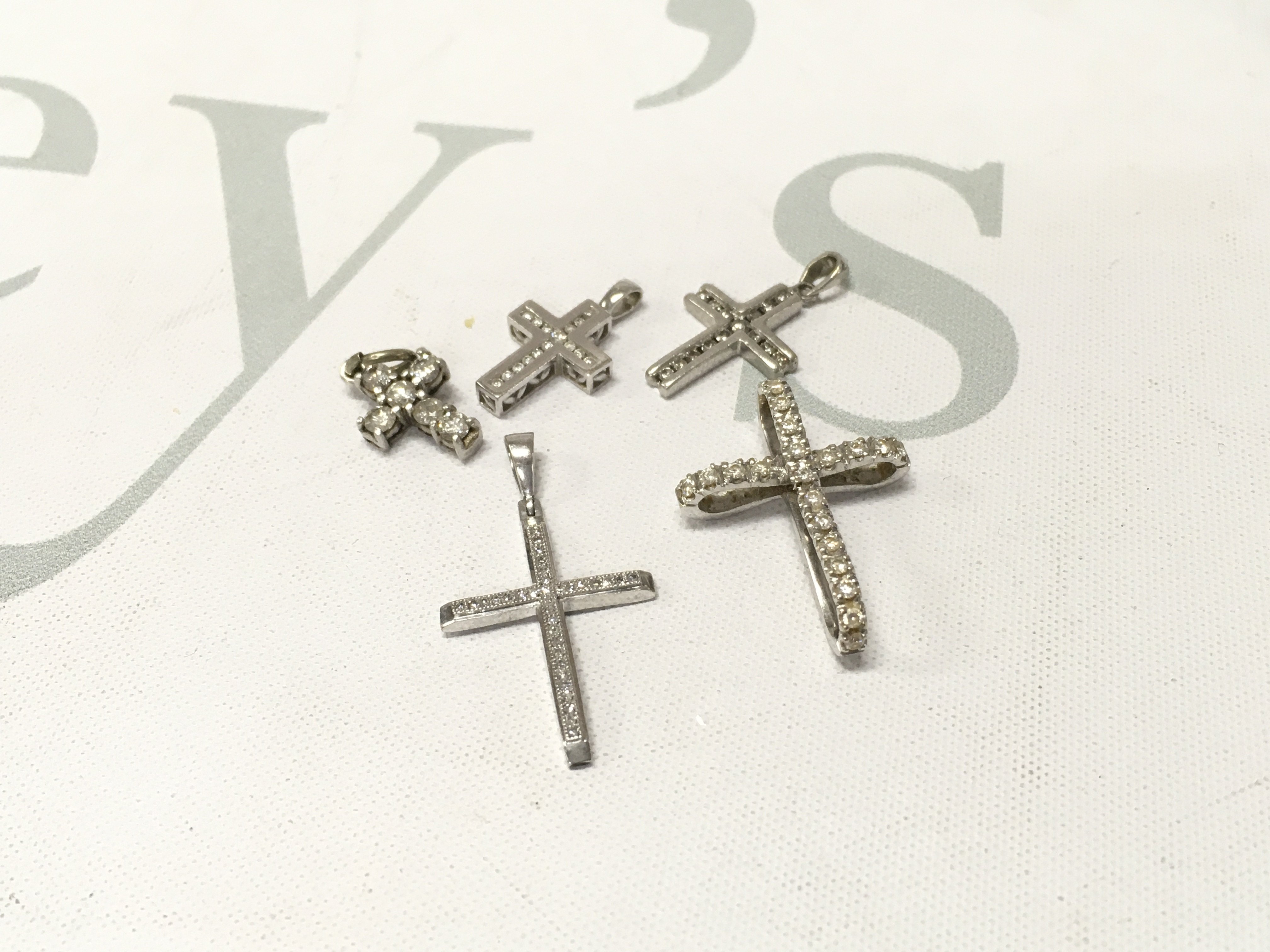 Five 9ct white gold diamond set crosses. Approx weight 9.4grams.