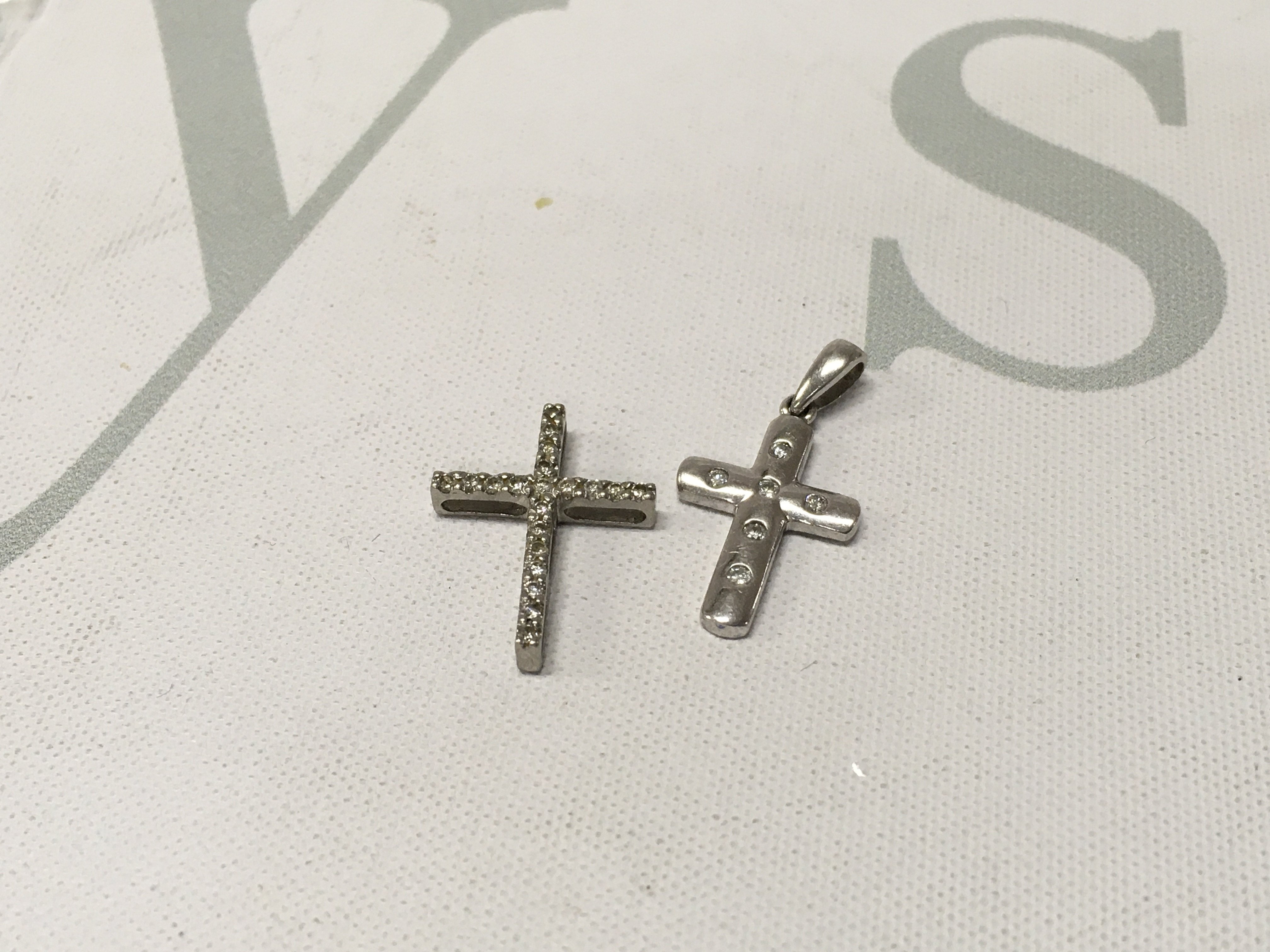 Two platinum diamond set crosses. Approx weight 2.5 grams.