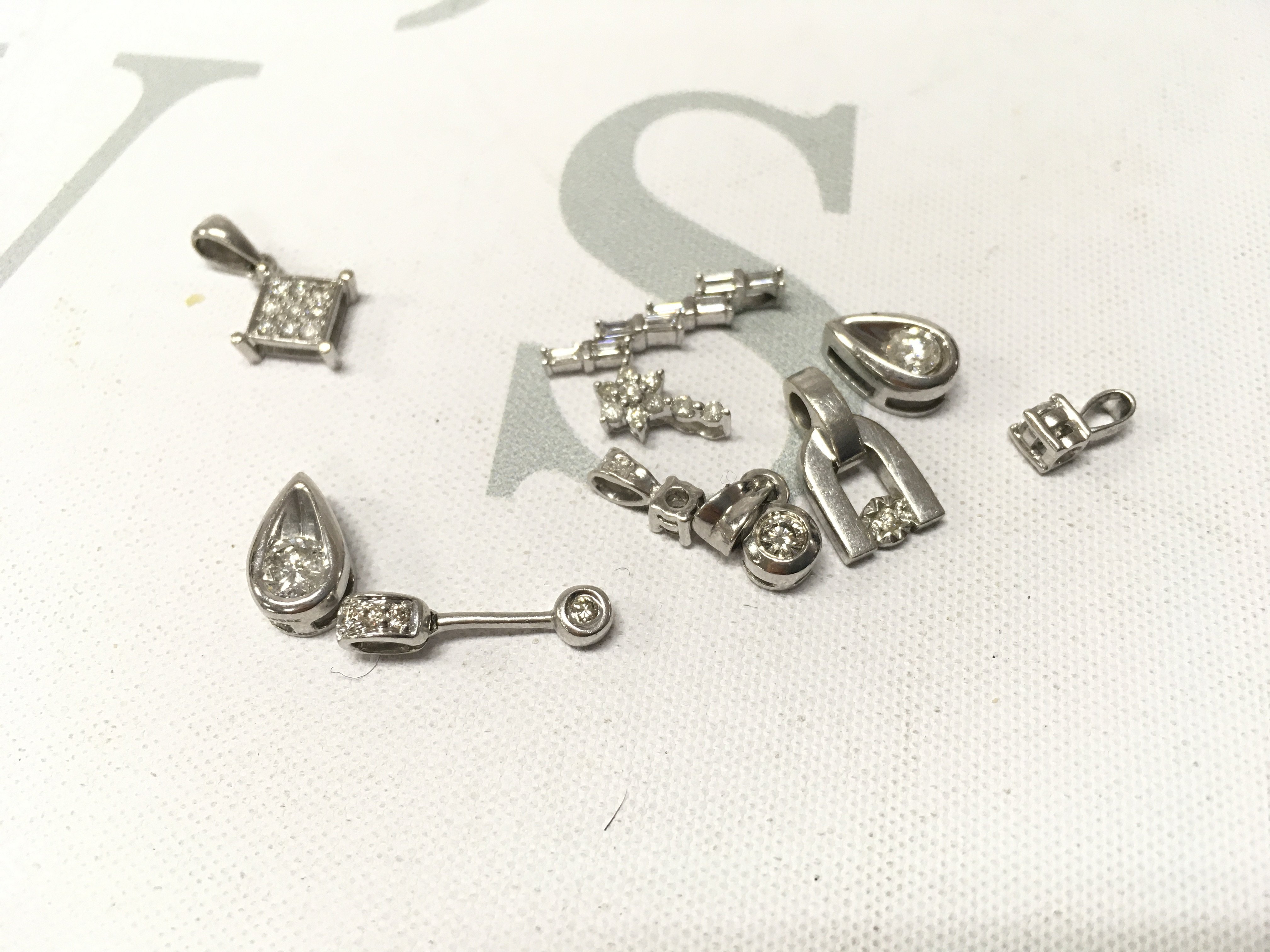 An assortment of 9ct white gold diamond set pendants. Approx weight 6.9grams.