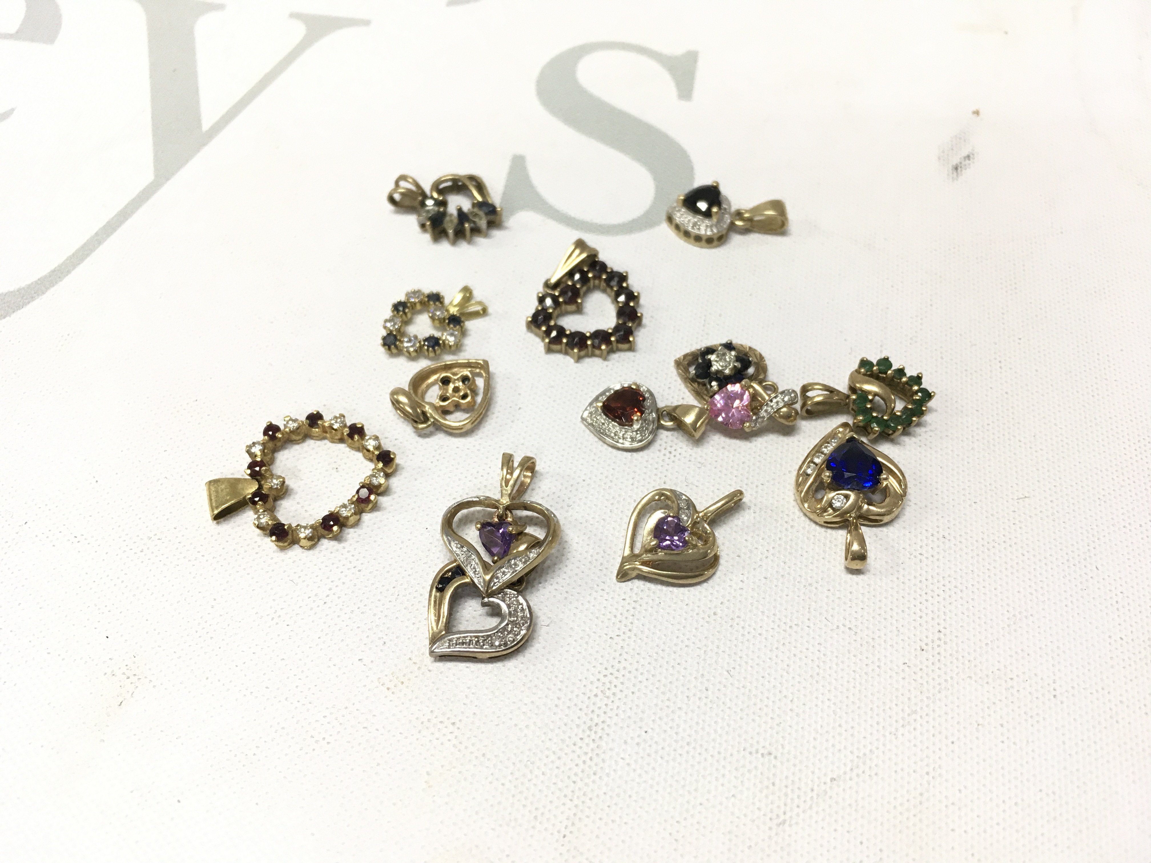 A mixed assortment of stone set 9ct gold heart pendants.