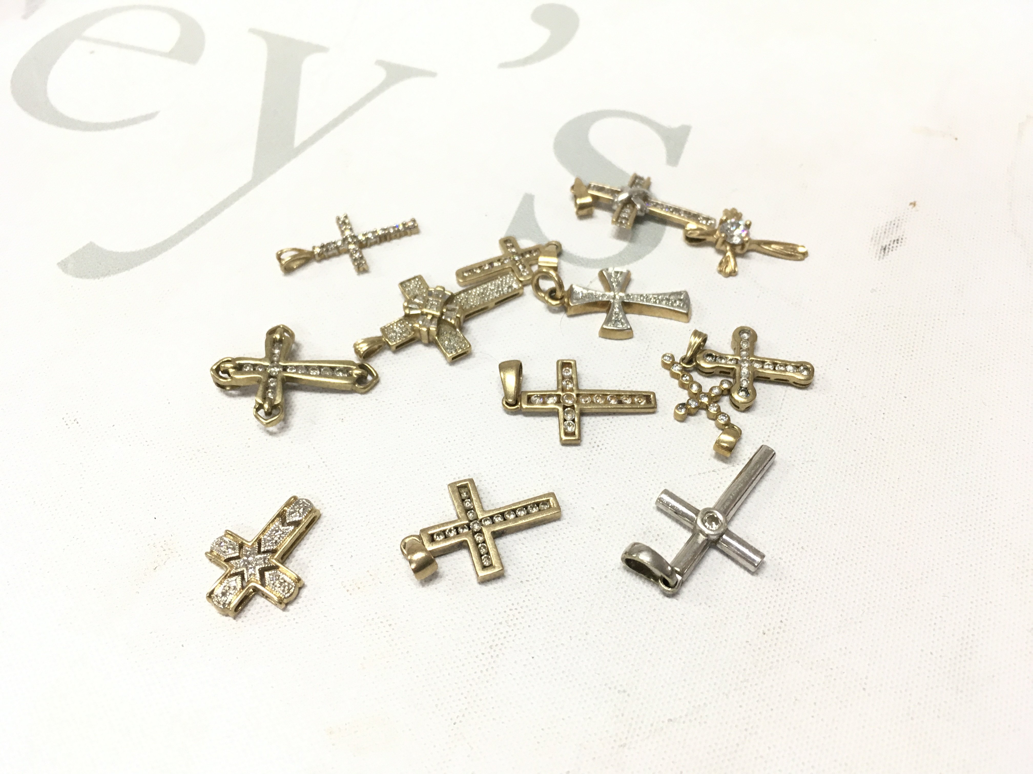 A mixed assortment of 9ct gold stone set crosses including two 14ct examples. Approx weight 20.1 grams.