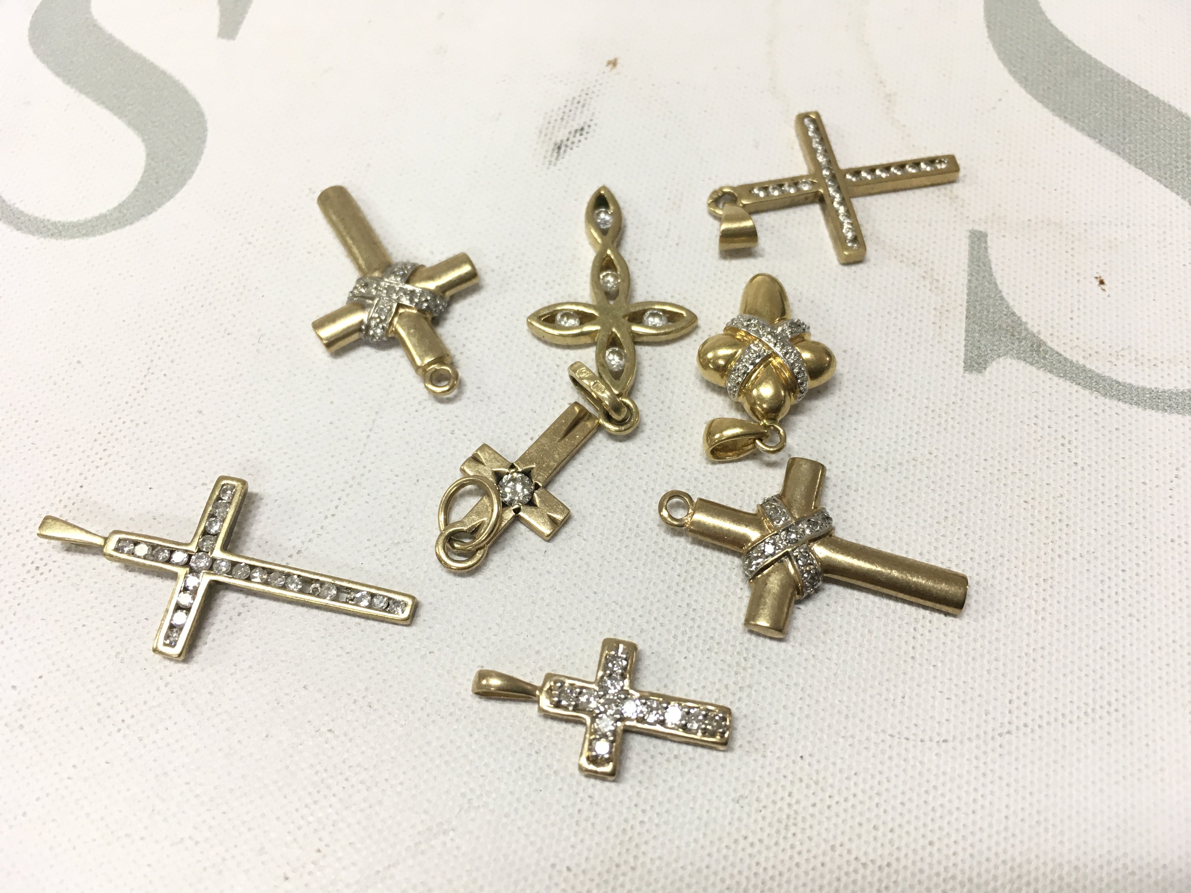 A mixed assortment of yellow metal stone set crosses. Approx weight 15.4 grams.