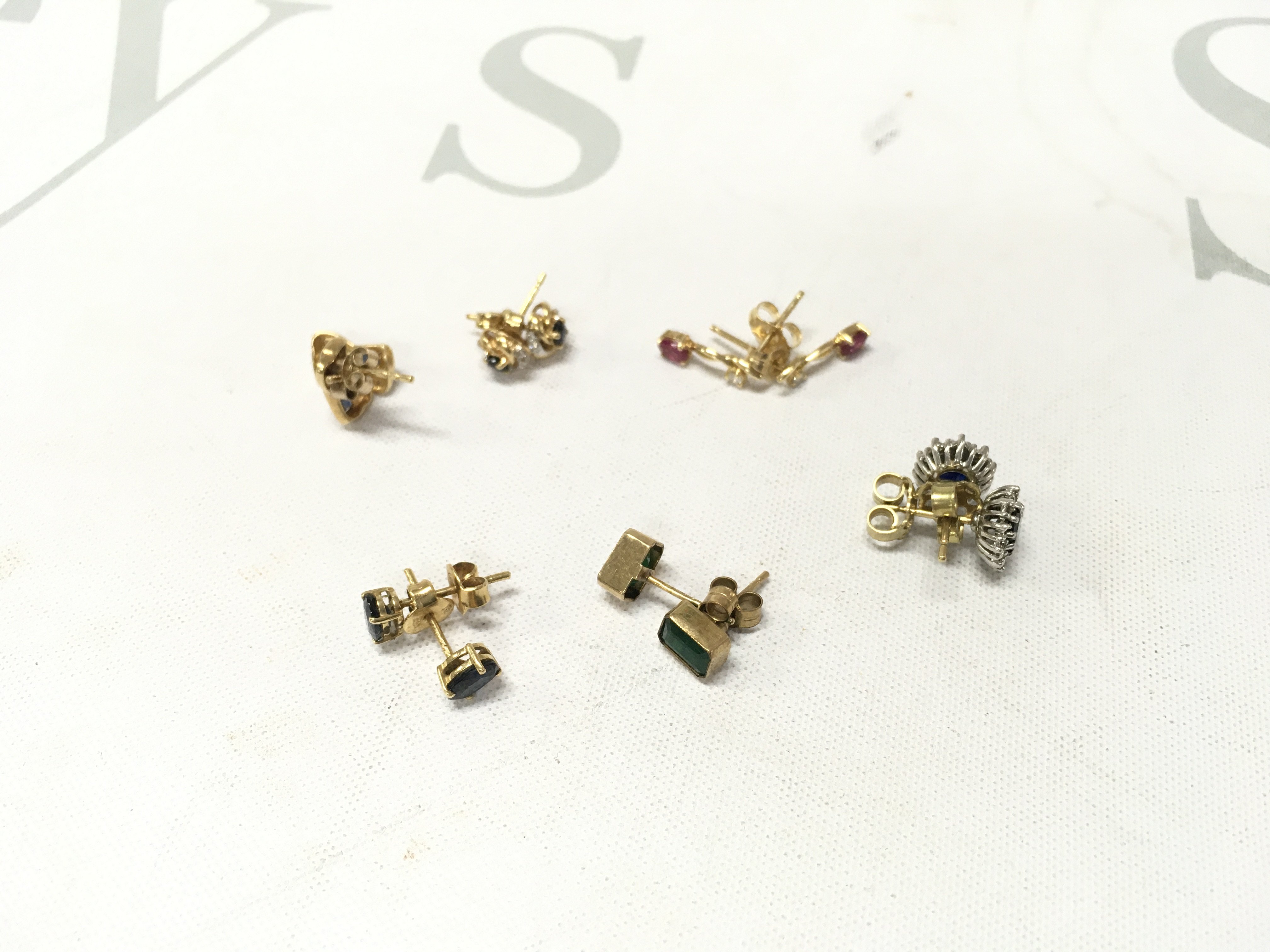 Six pairs of 18ct gold stone set studs. Approx weight 8.2 grams.