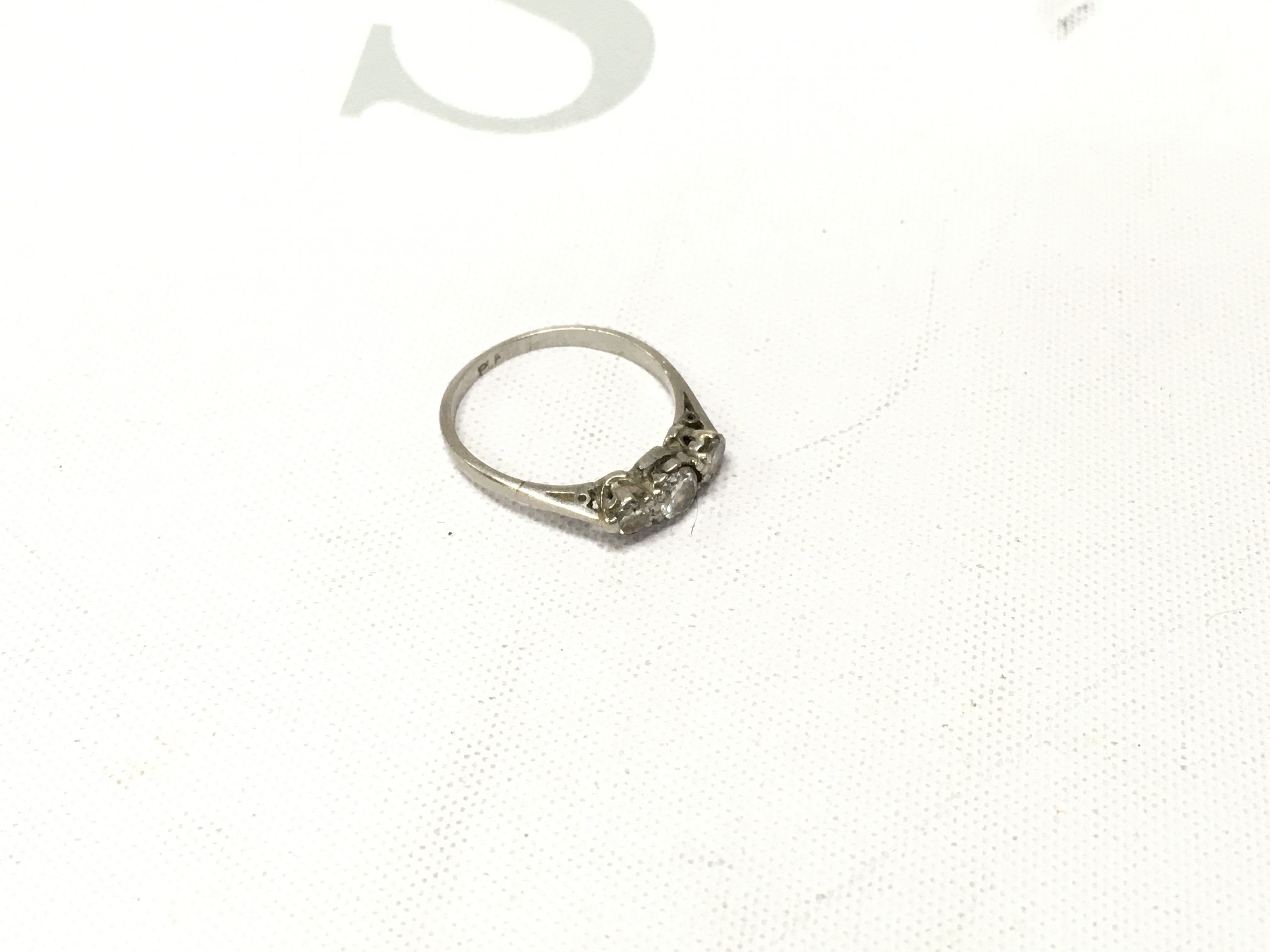 A platinum three stone ring, Approx size J, Approx weight 1.9 grams.