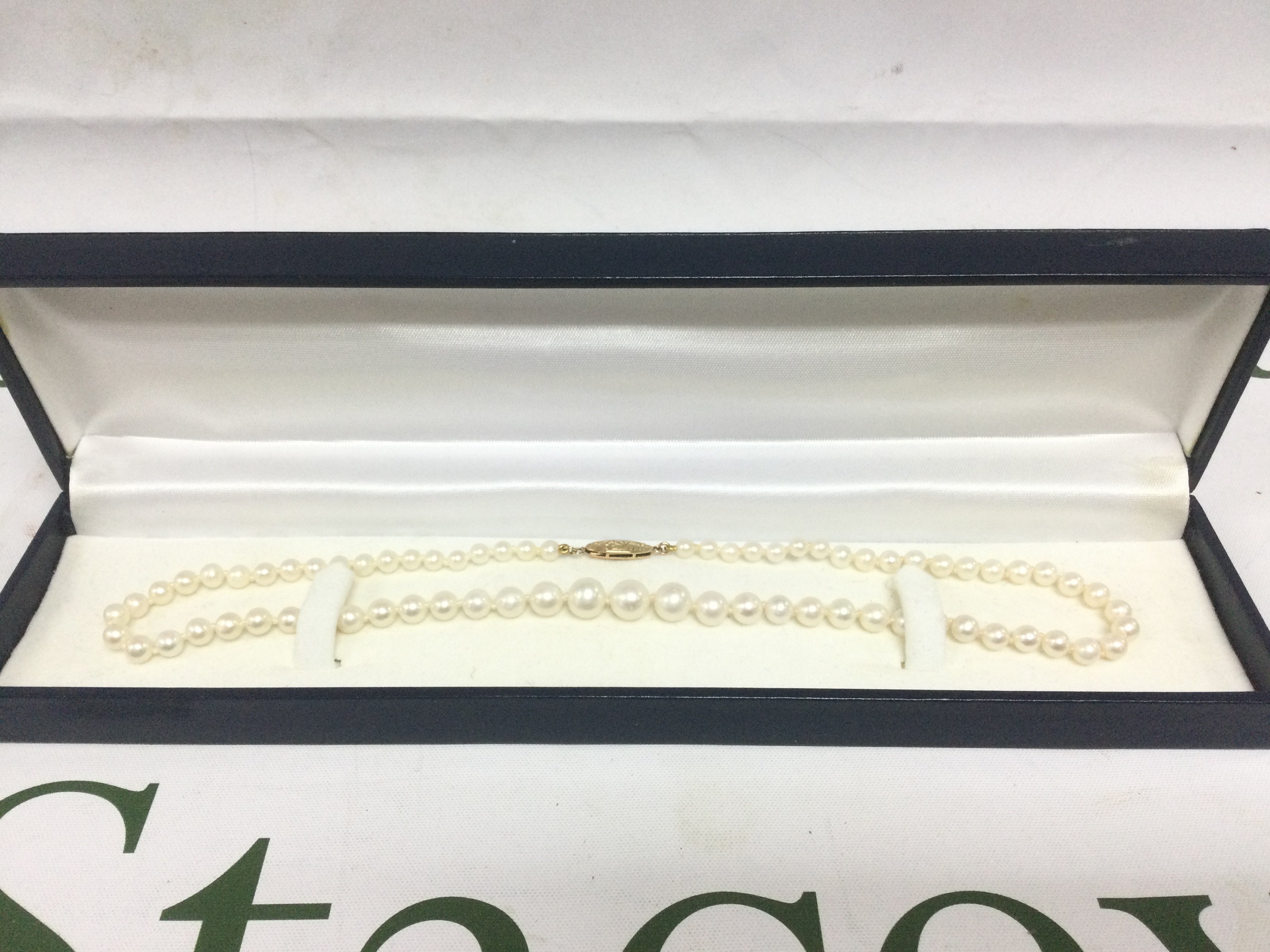 A boxed cultured pearl necklace with a 14k gold clasp. Shipping category A.