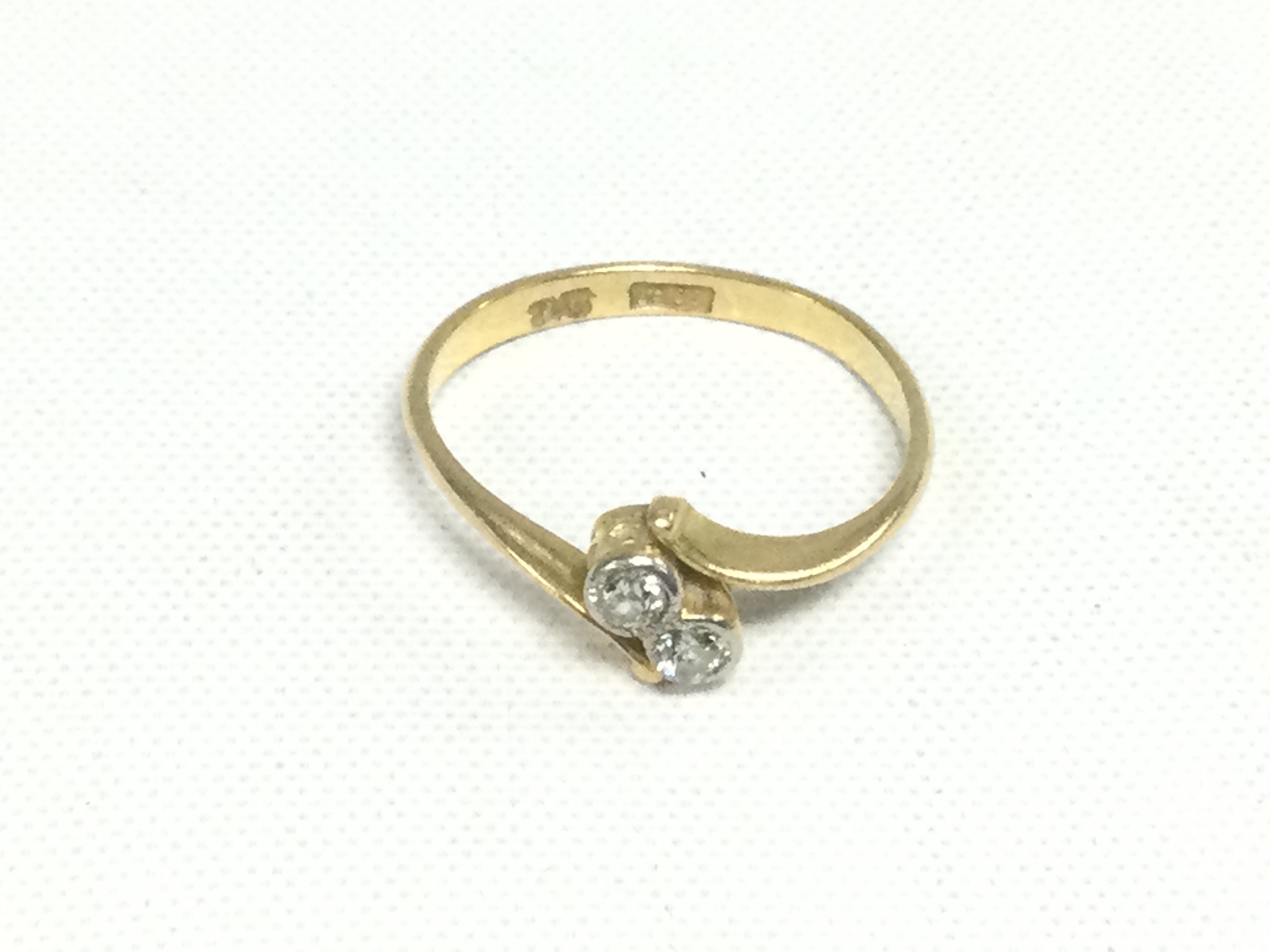An 18ct gold two stone diamond ring, approx 1.8g, approx size L. Shipping category A.