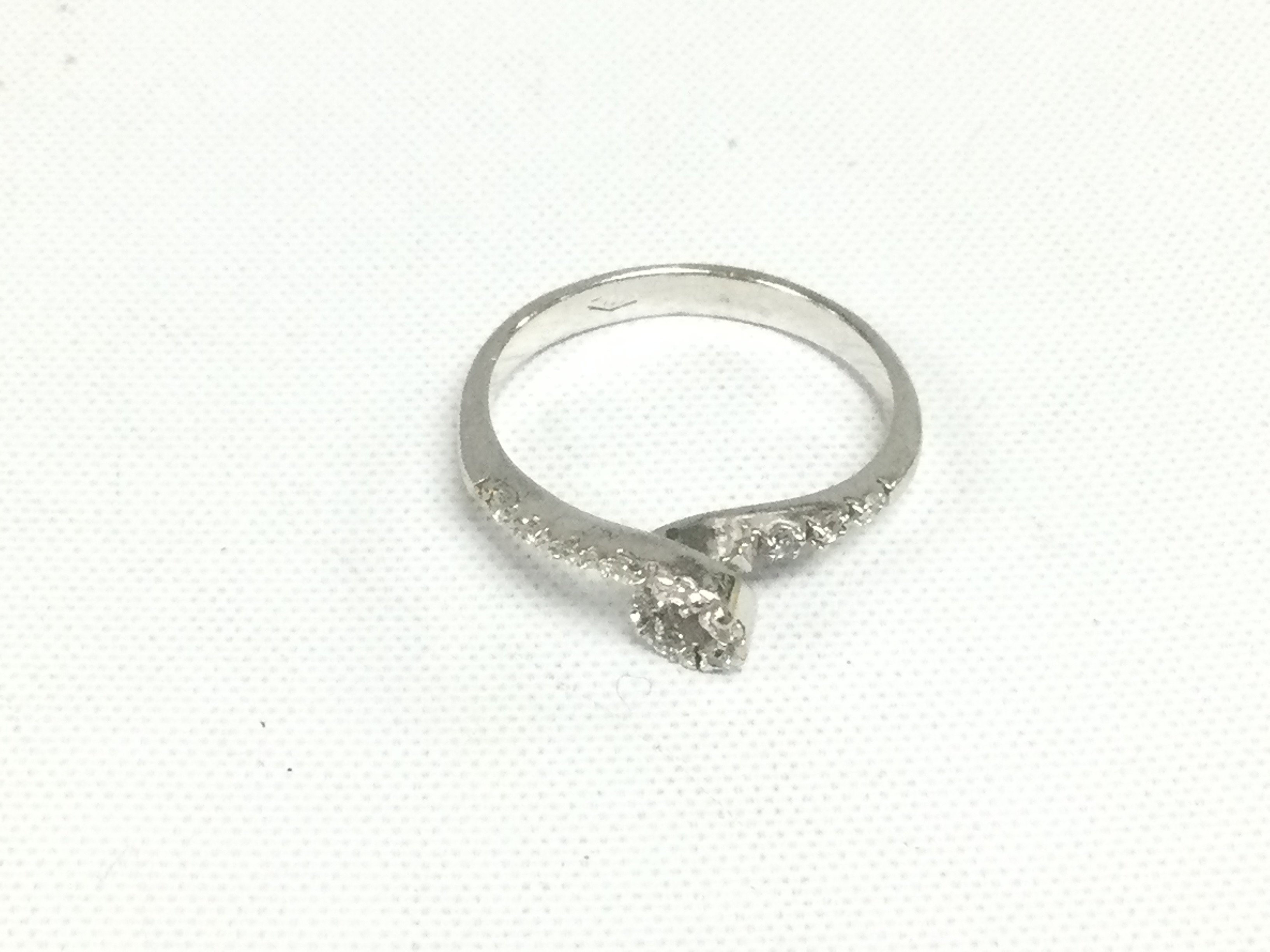 An 18ct white gold loop design ring set with diamonds. Approx 2.5g and approx size O. Shipping category A.