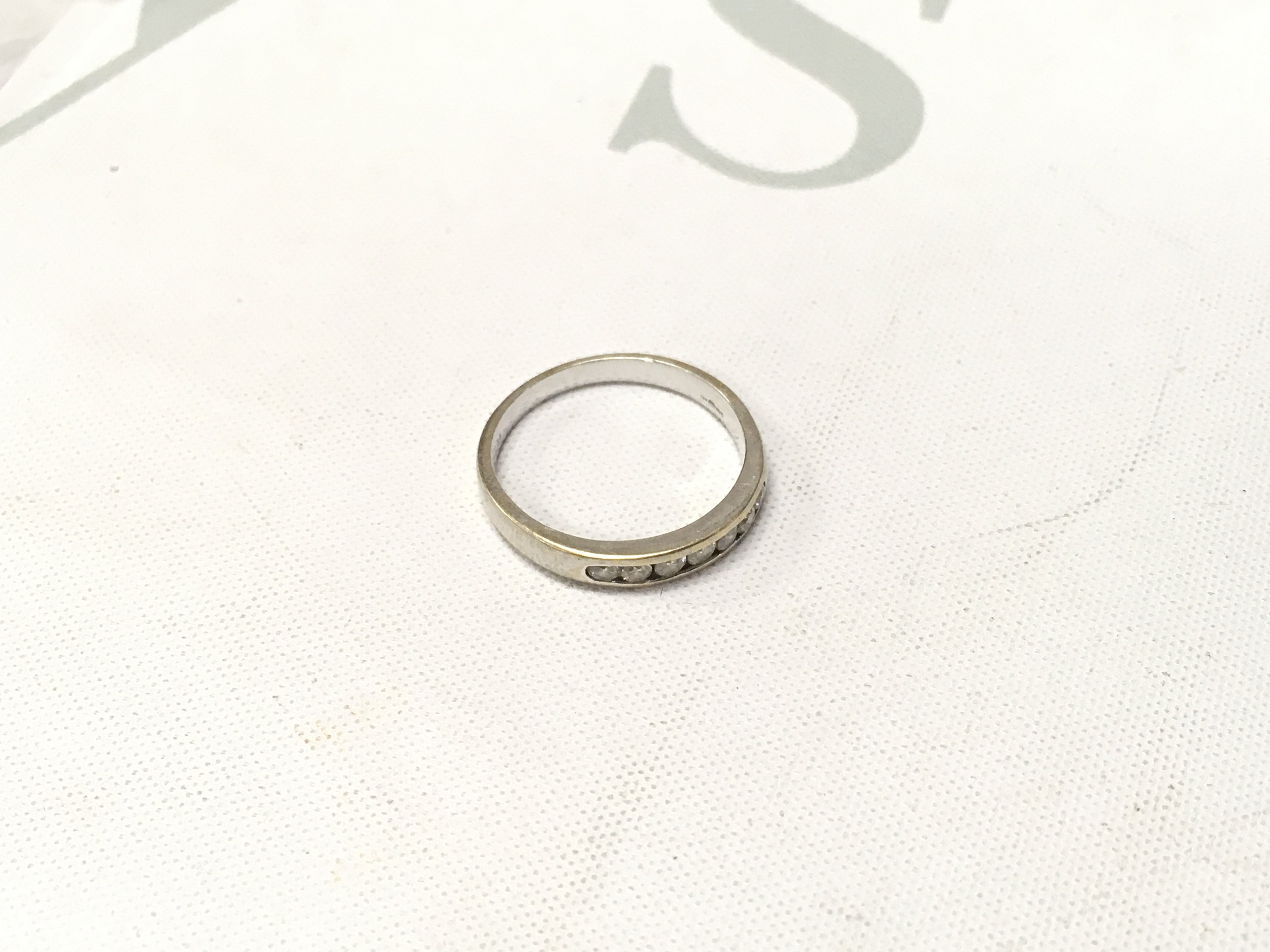 An 18ct white gold stone set band. Approx size P, Approx weight 3.4 grams.