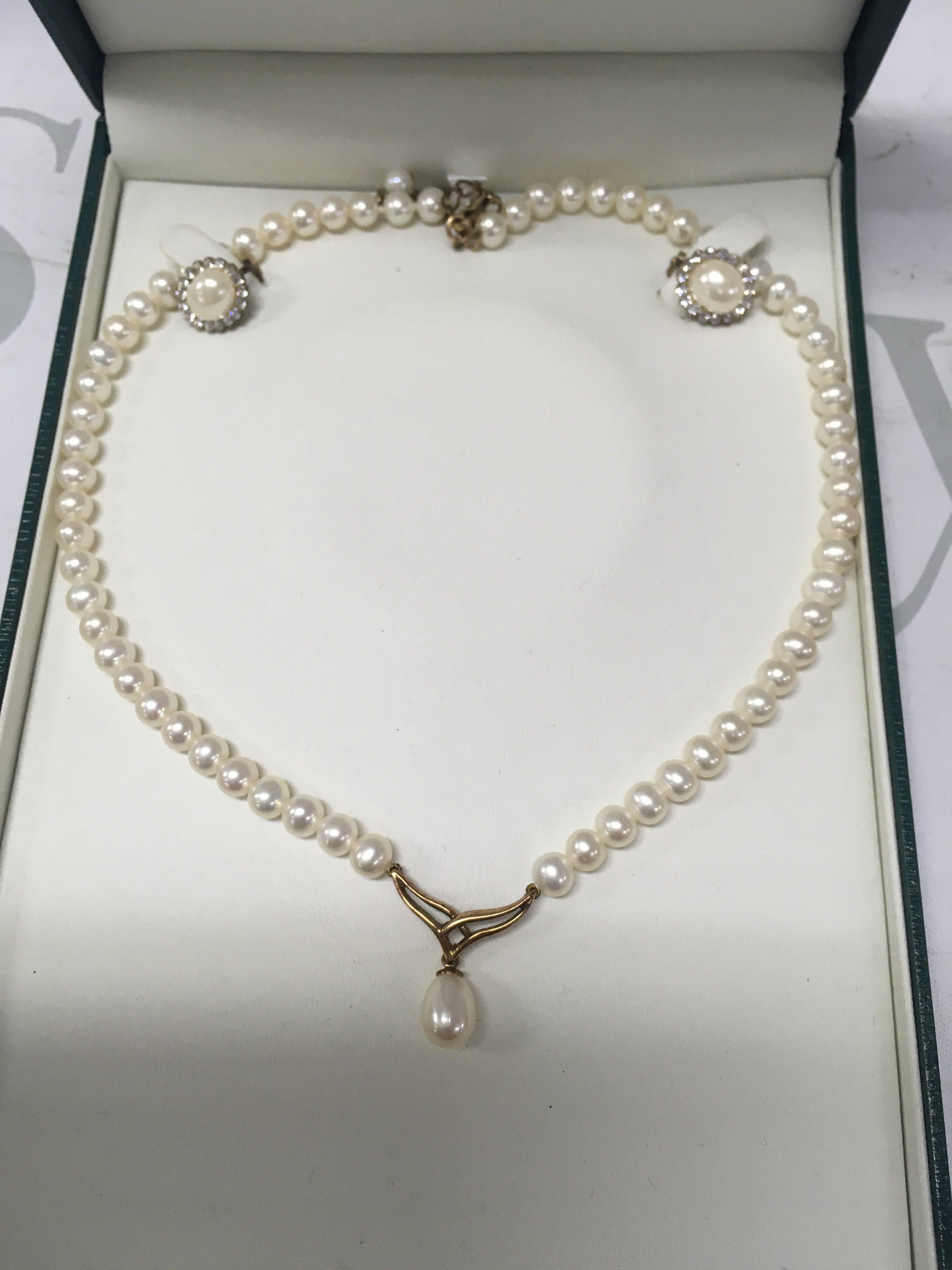 A pearl necklaces with 9 ct gold clasp and matching pair of earrings.