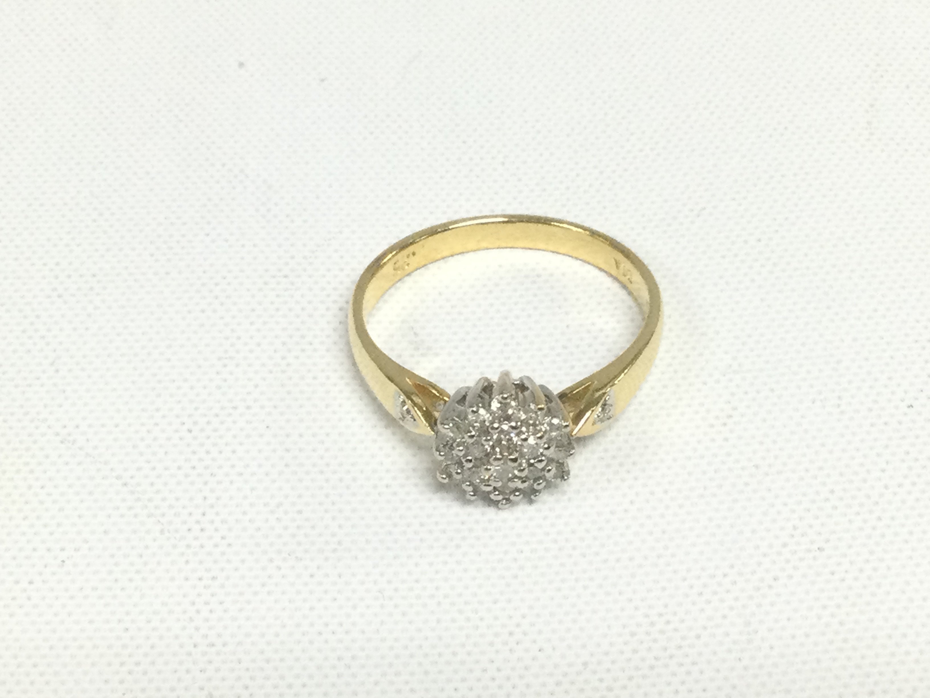 An 18ct gold diamond cluster ring, approx 3.5g, approx 1/4ct and approx size N. Shipping category A.