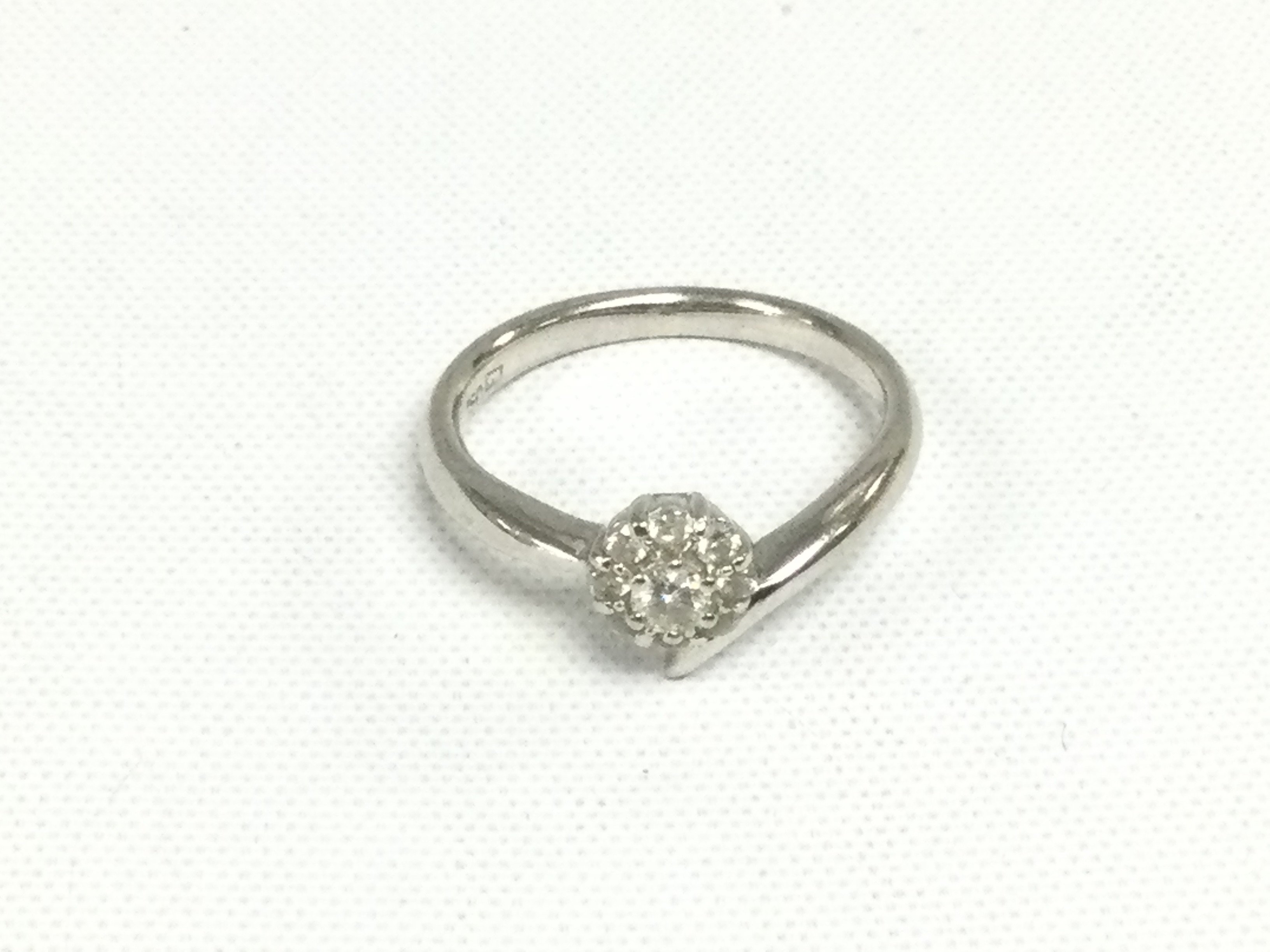 An 18ct white gold diamond cluster ring in the form of a flowerhead, approx 3.1g and approx size K. Shipping category A.