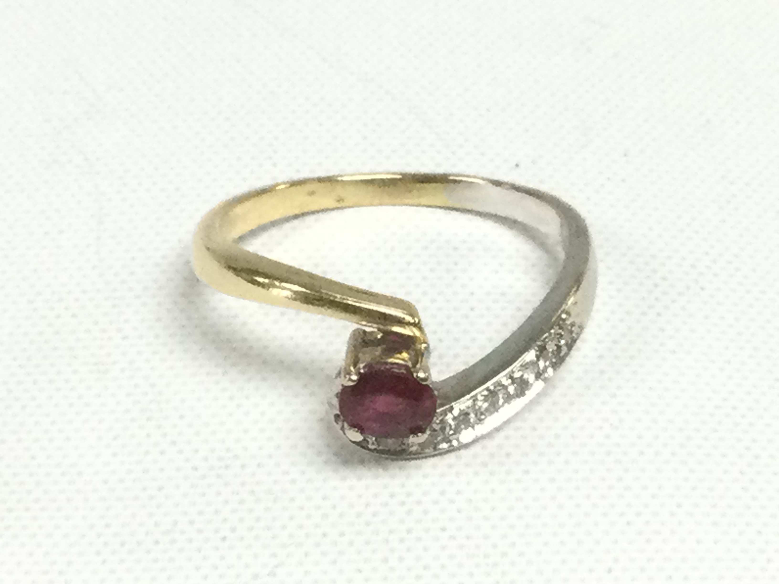 A 14ct gold diamond and ruby twist ring, approx 2.6g and approx size K-L. Shipping category A.