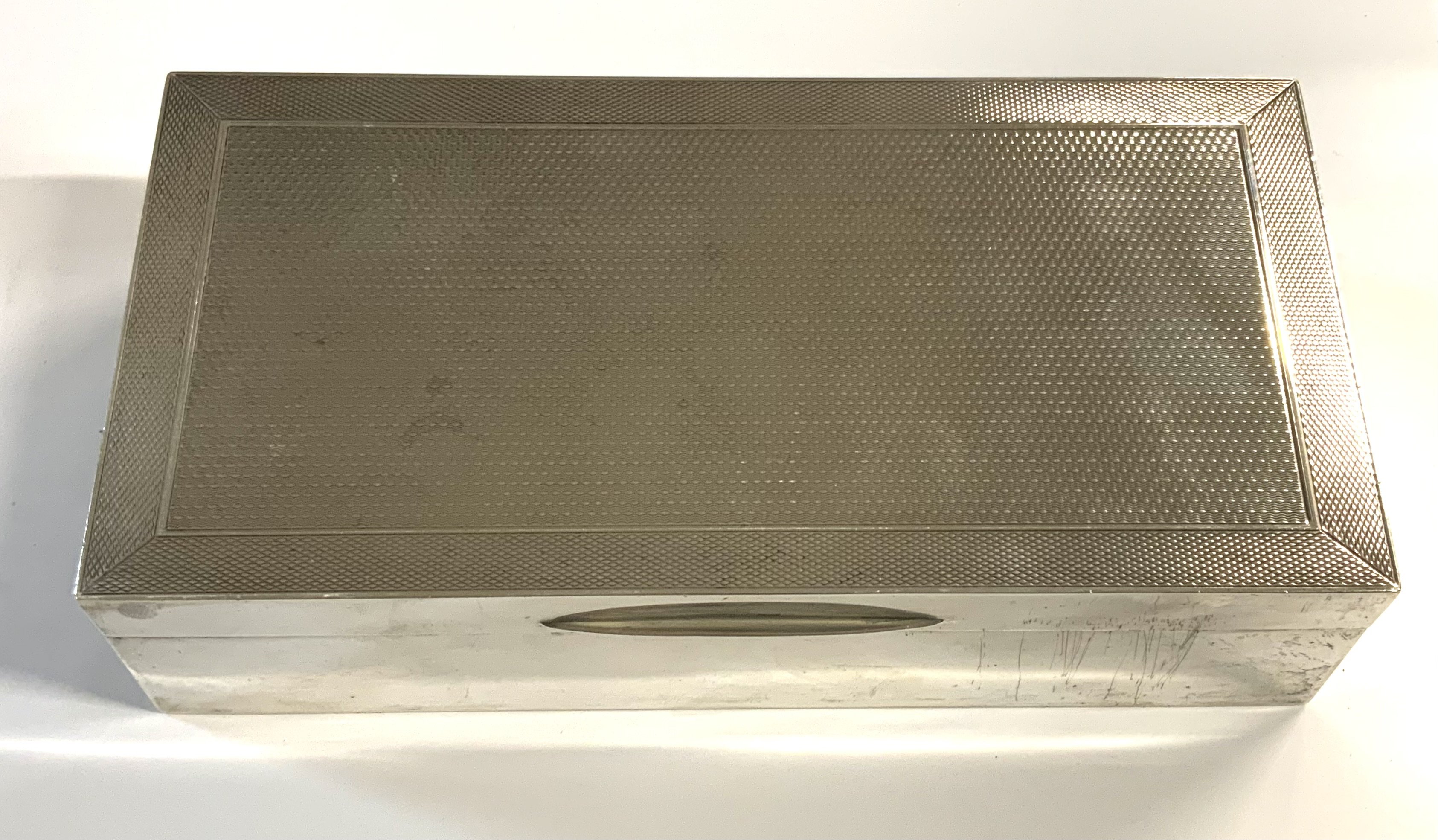 A hallmarked silver cigarette box with engine turned decoration to cover, marks for Mappin & Webb, London 1931.