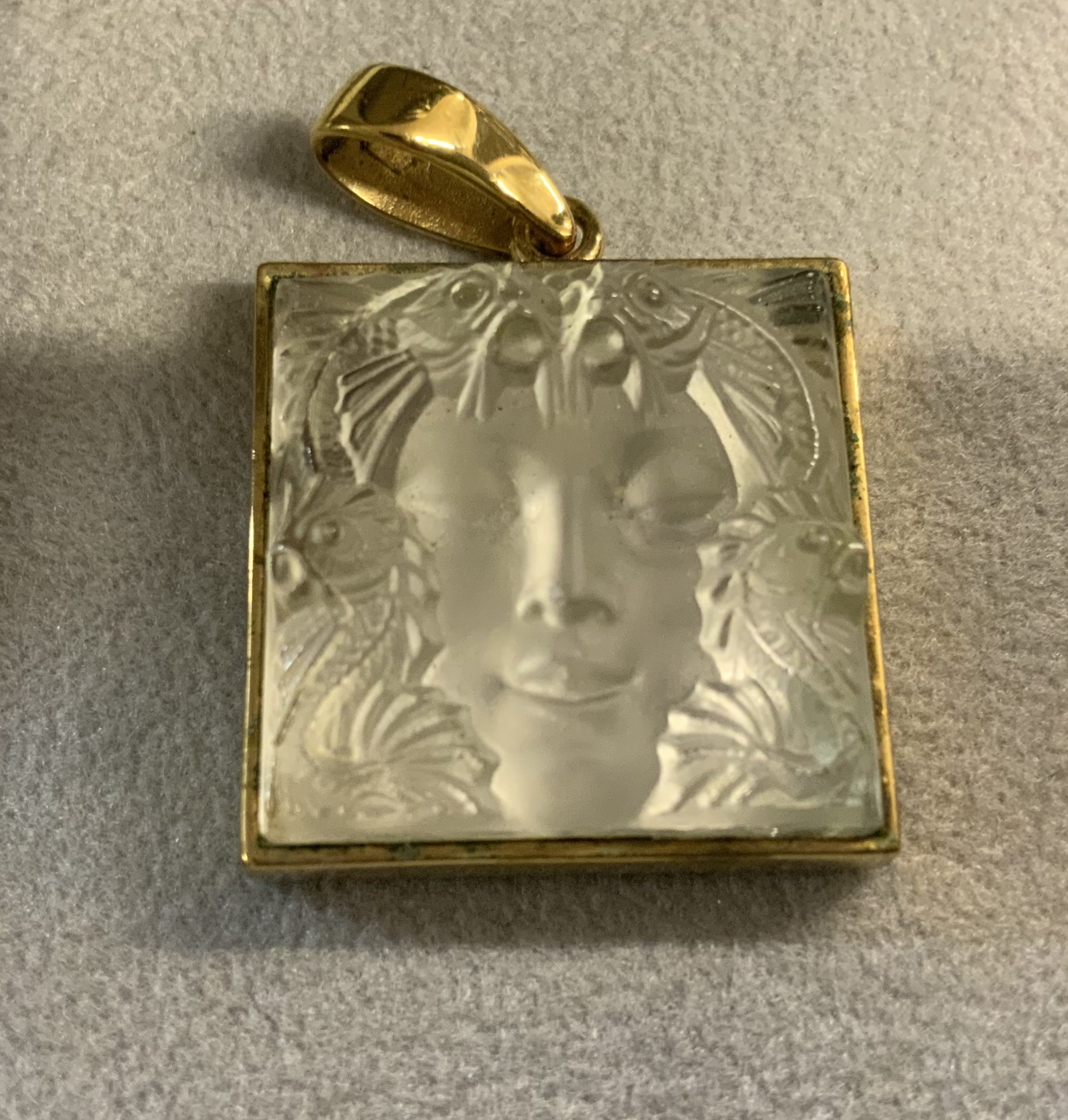 LALIQUE "MASQUE DE FEMME" CRYSTAL PENDANT & EARRINGS Mid-20th Century Raised woman's face surrounded by Ocean Life, mounted on a gold-plated 1.25" square. Marked "Lalique" and stamped on reverse.
