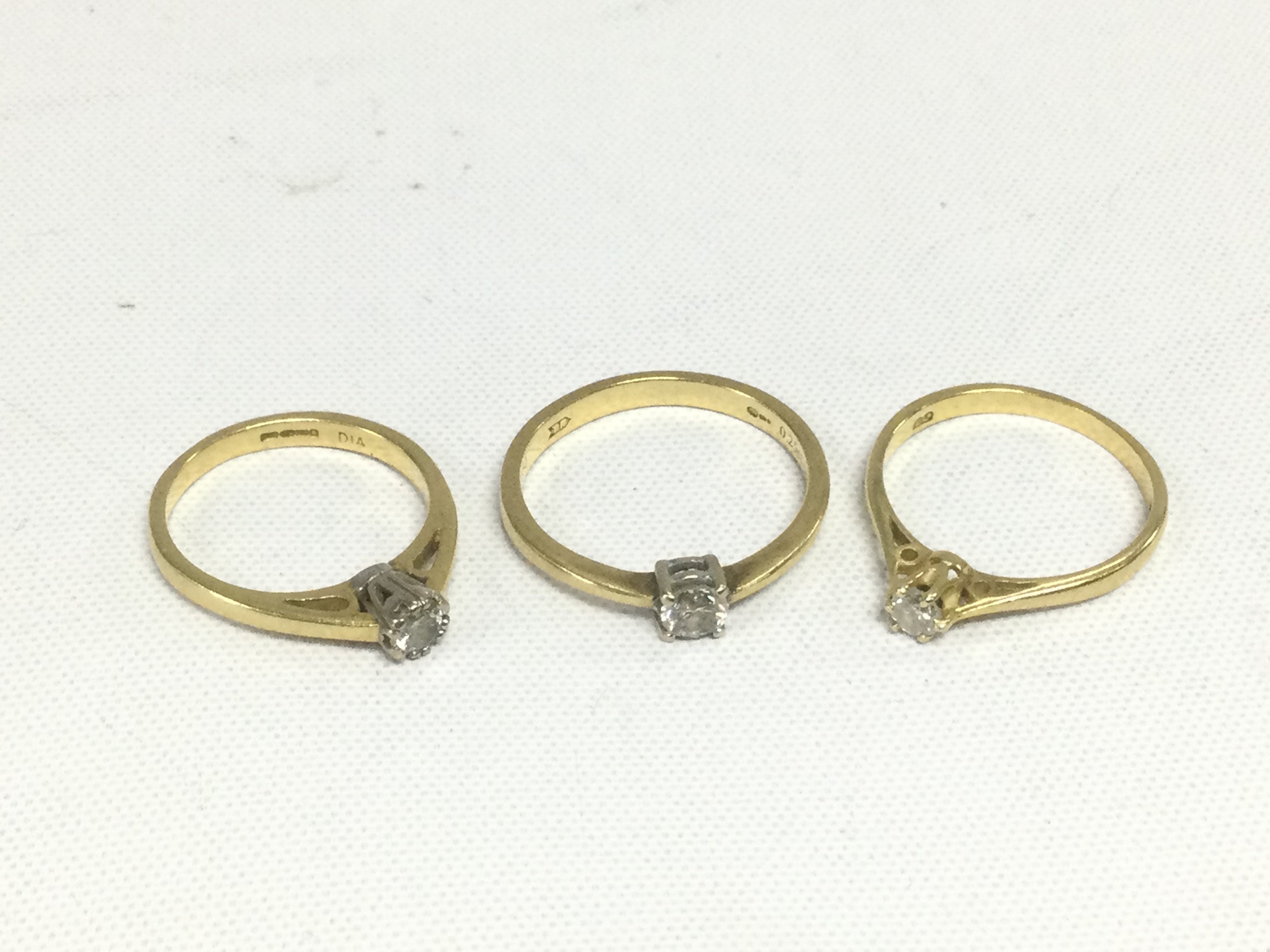 Three 18ct gold diamond solitaire rings, approx total weight 6.4g and approx sizes K, H and M. Shipping category A.