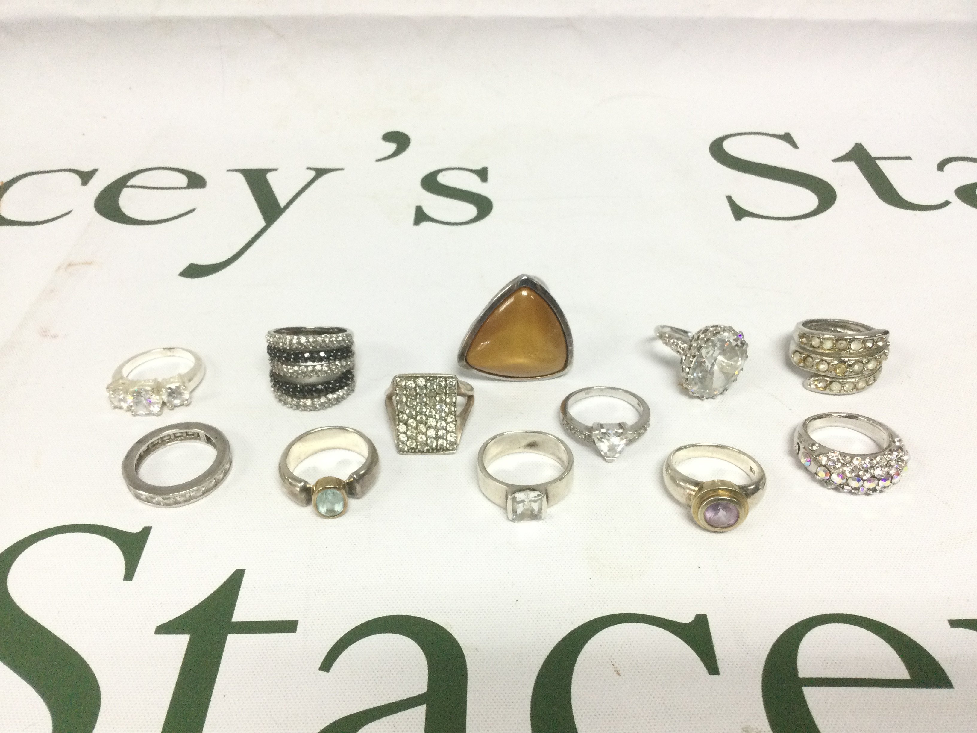 Twelve silver and white metal rings set with stones. Shipping category A.