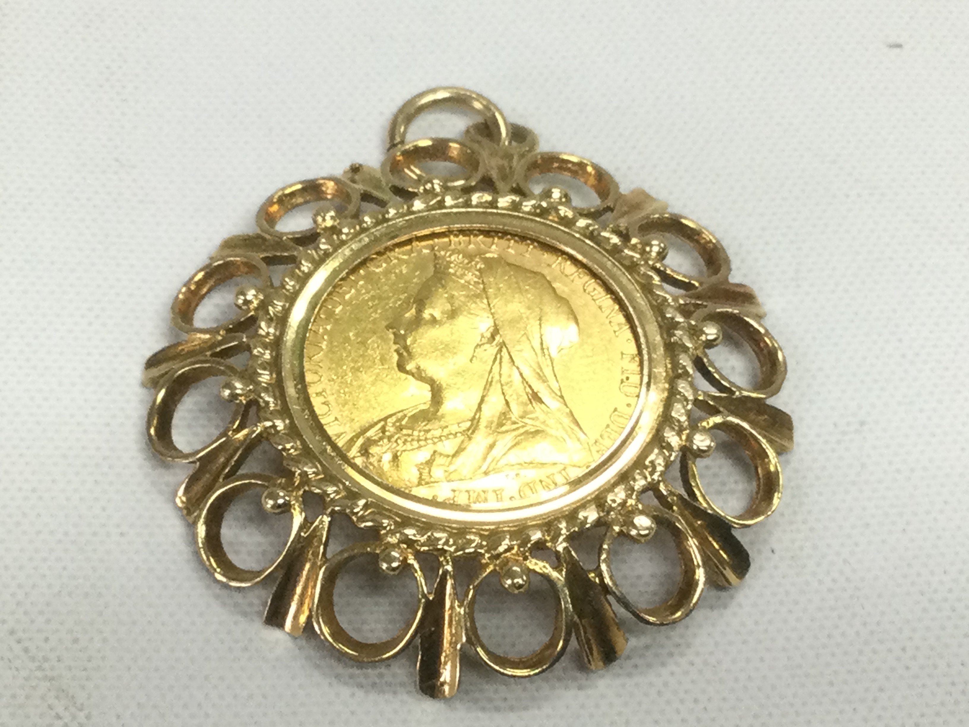 A 1901 full sovereign in a gold mount, approx 13.3g. Shipping category A.