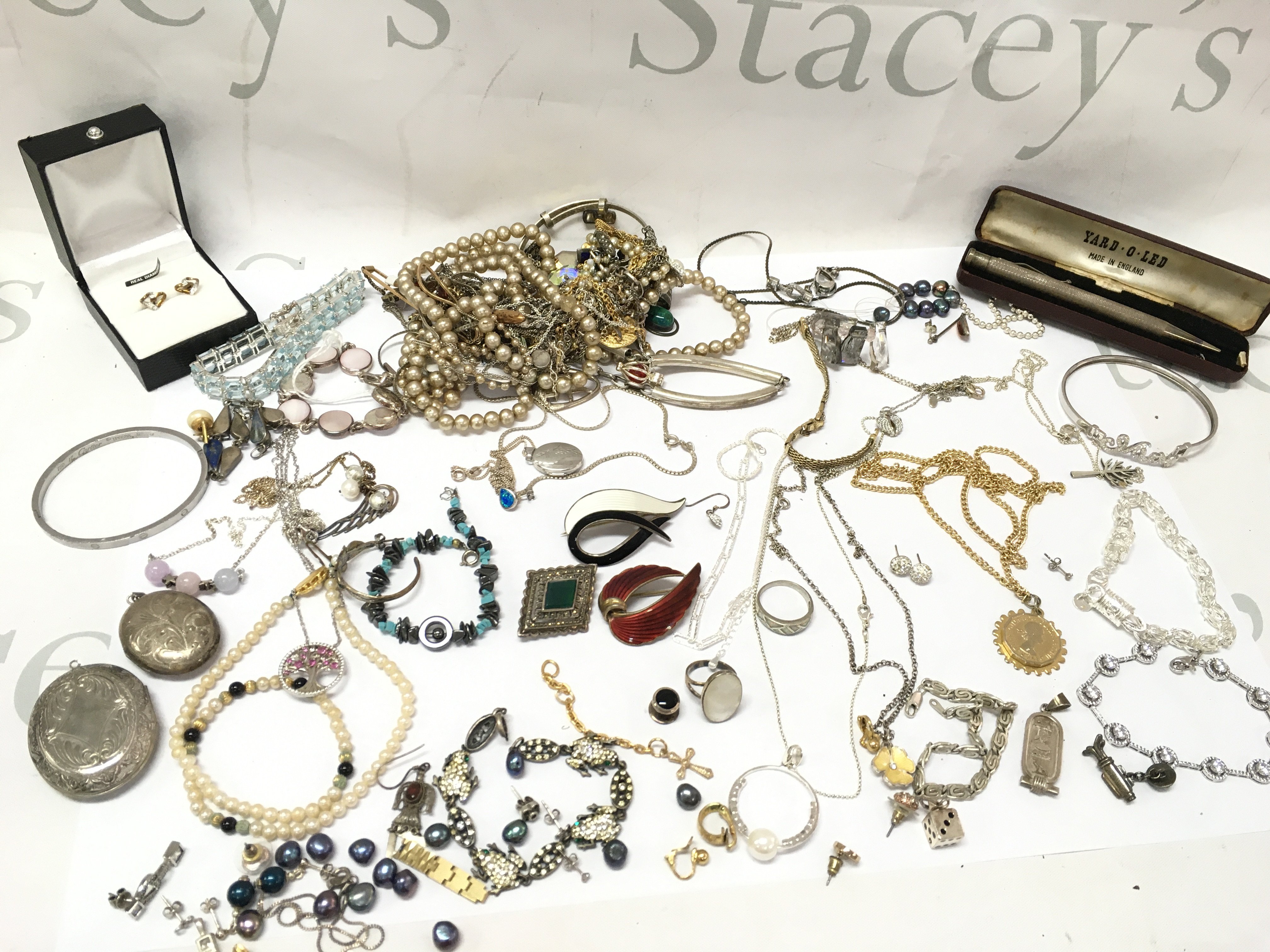 A collection of jewellery including enamel and silver brooches , silver necklaces, rings , silver Yard O Led pen, silver locket pendant etc . Postage category B