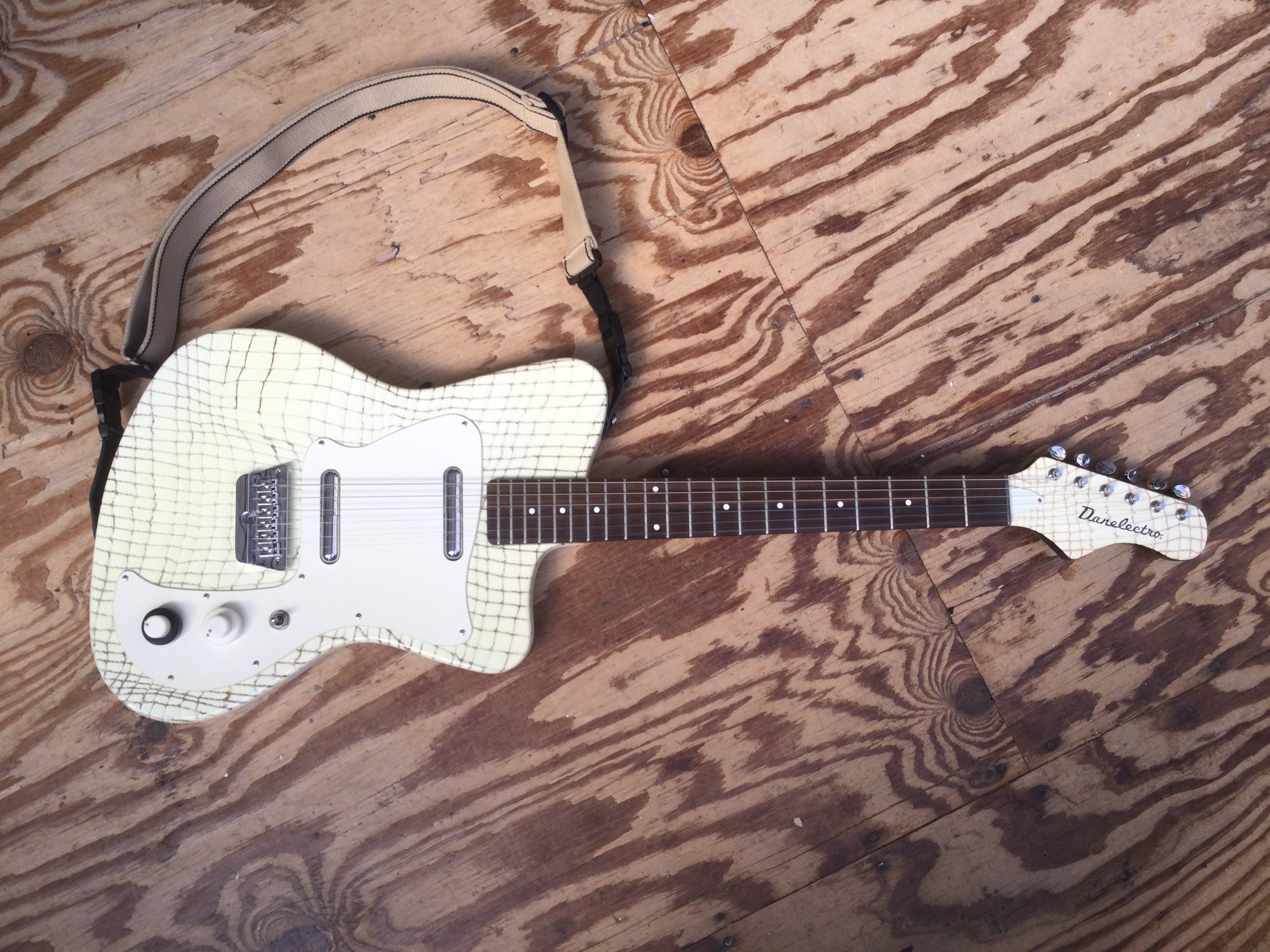A Danelectro 67 Heaven electric guitar with an alligator skin style finish. Cones with a soft carry case.