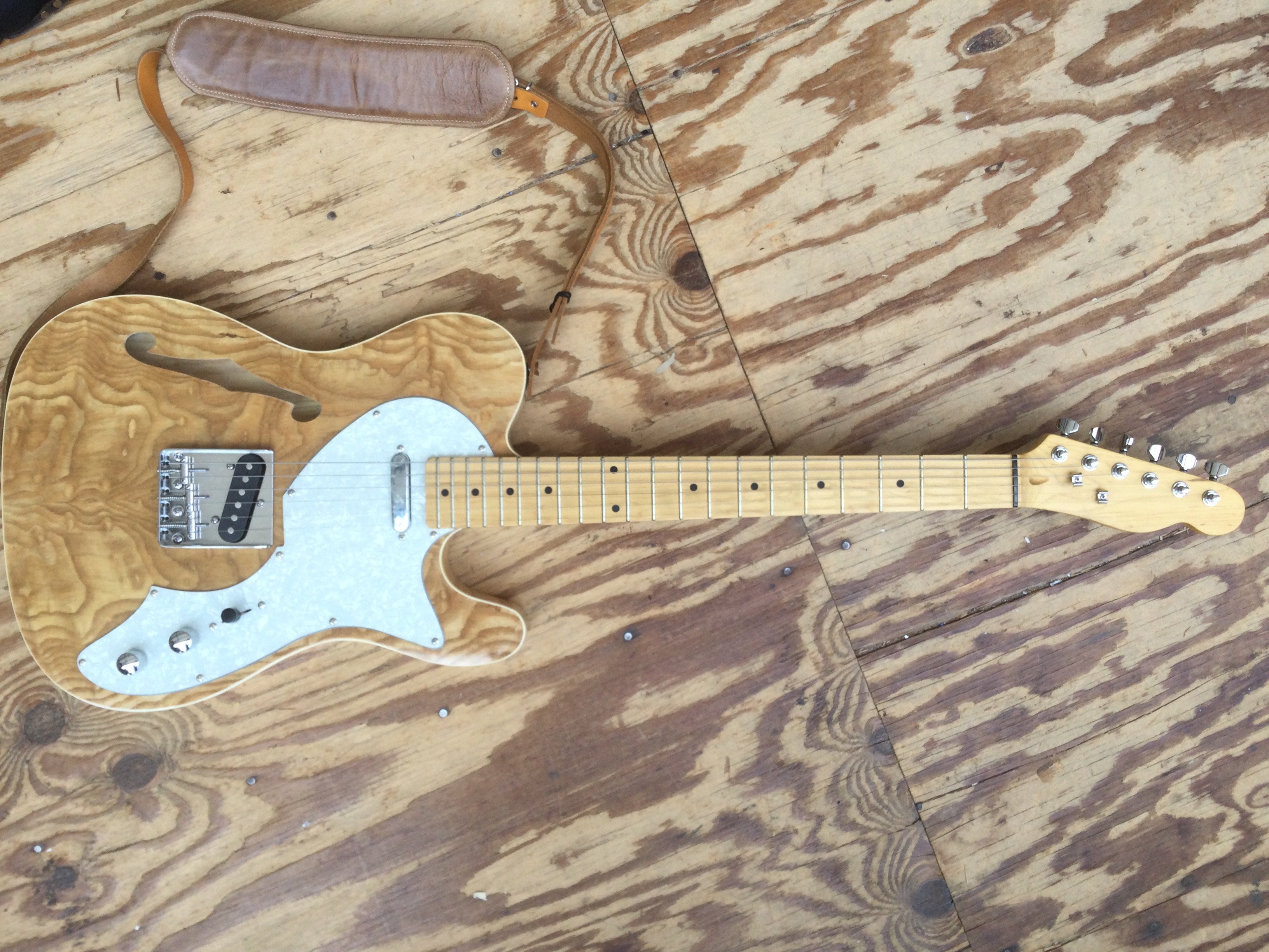 A thinline Telecaster type electric guitar. No maker's name. Comes with a Fender Squier soft carry case.