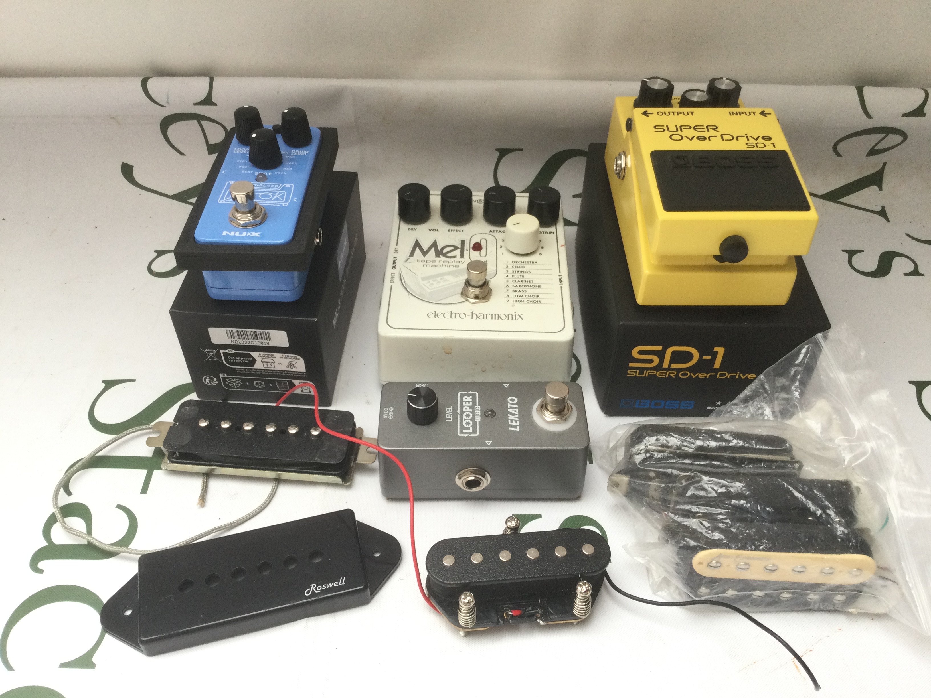 A collection of guitar pedals and pickups comprising an Electro Harmonix Mel9, a boxed Boss SD-1, a boxed NDL3 Hook drum & loop etc.