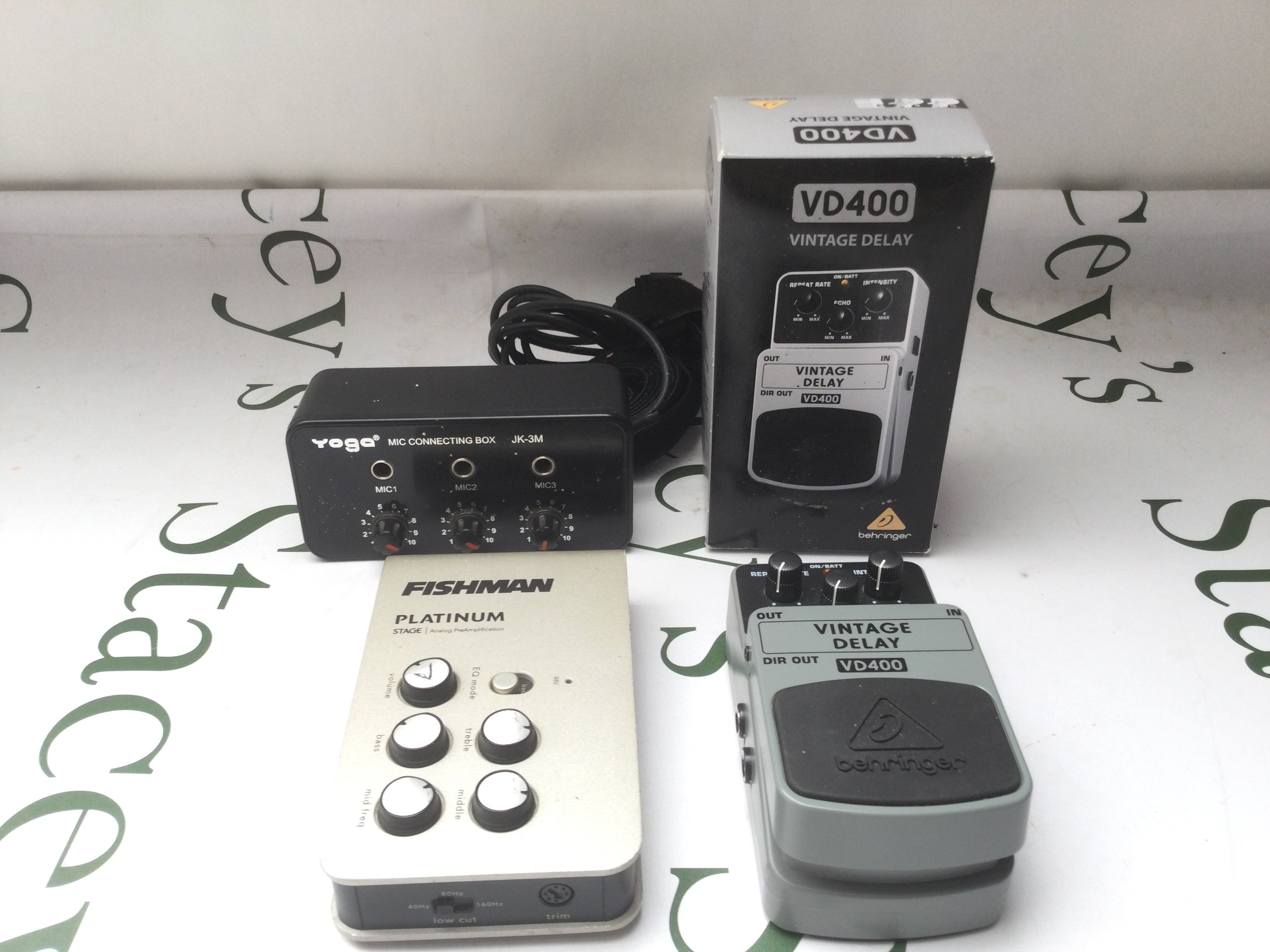 A Fishman Platinum Stage pre amp unit, a boxed VD400 vintage delay pedal and a Yoga mic connecting box.