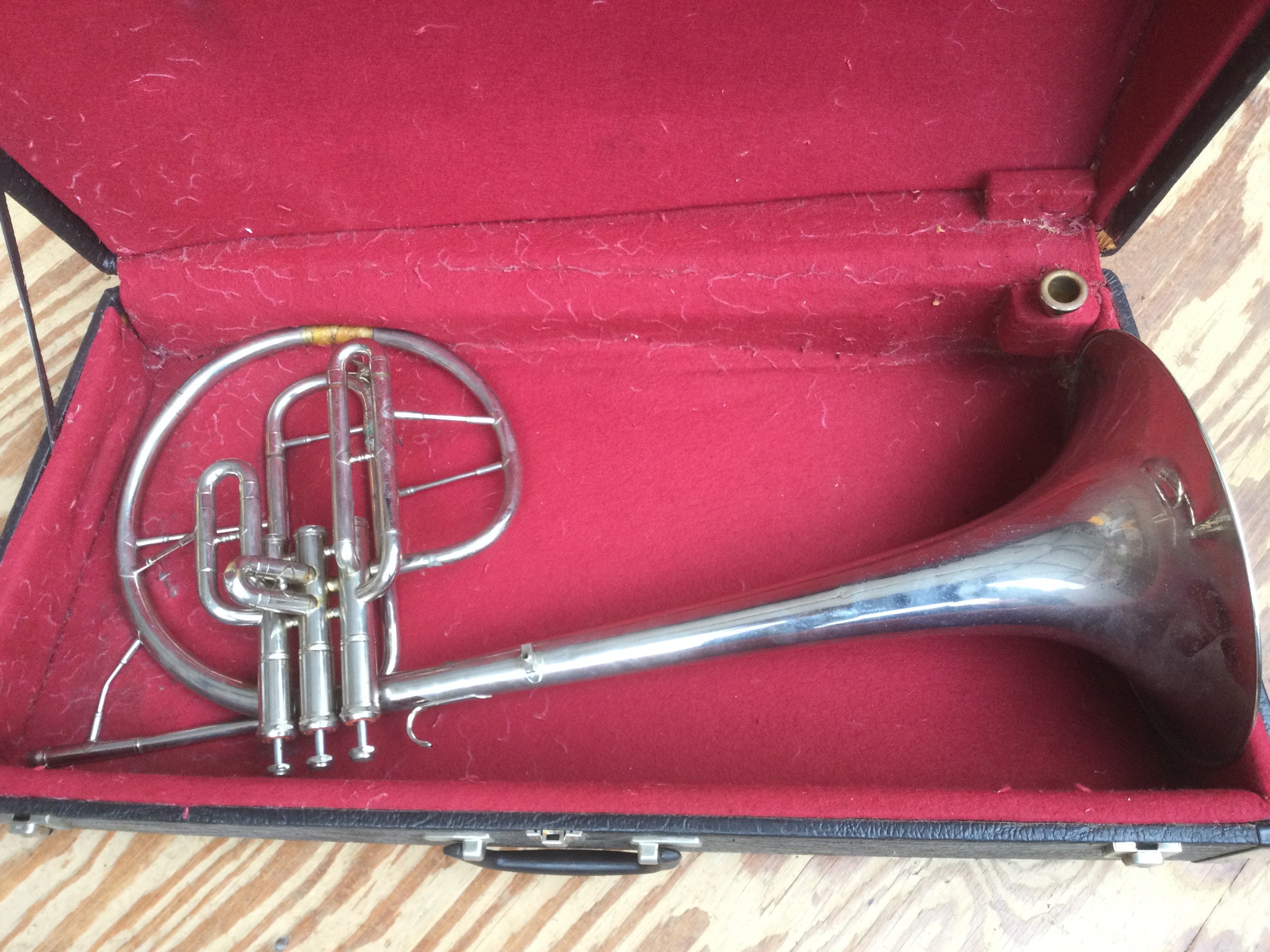 A cased Mellophone with mouthpiece.