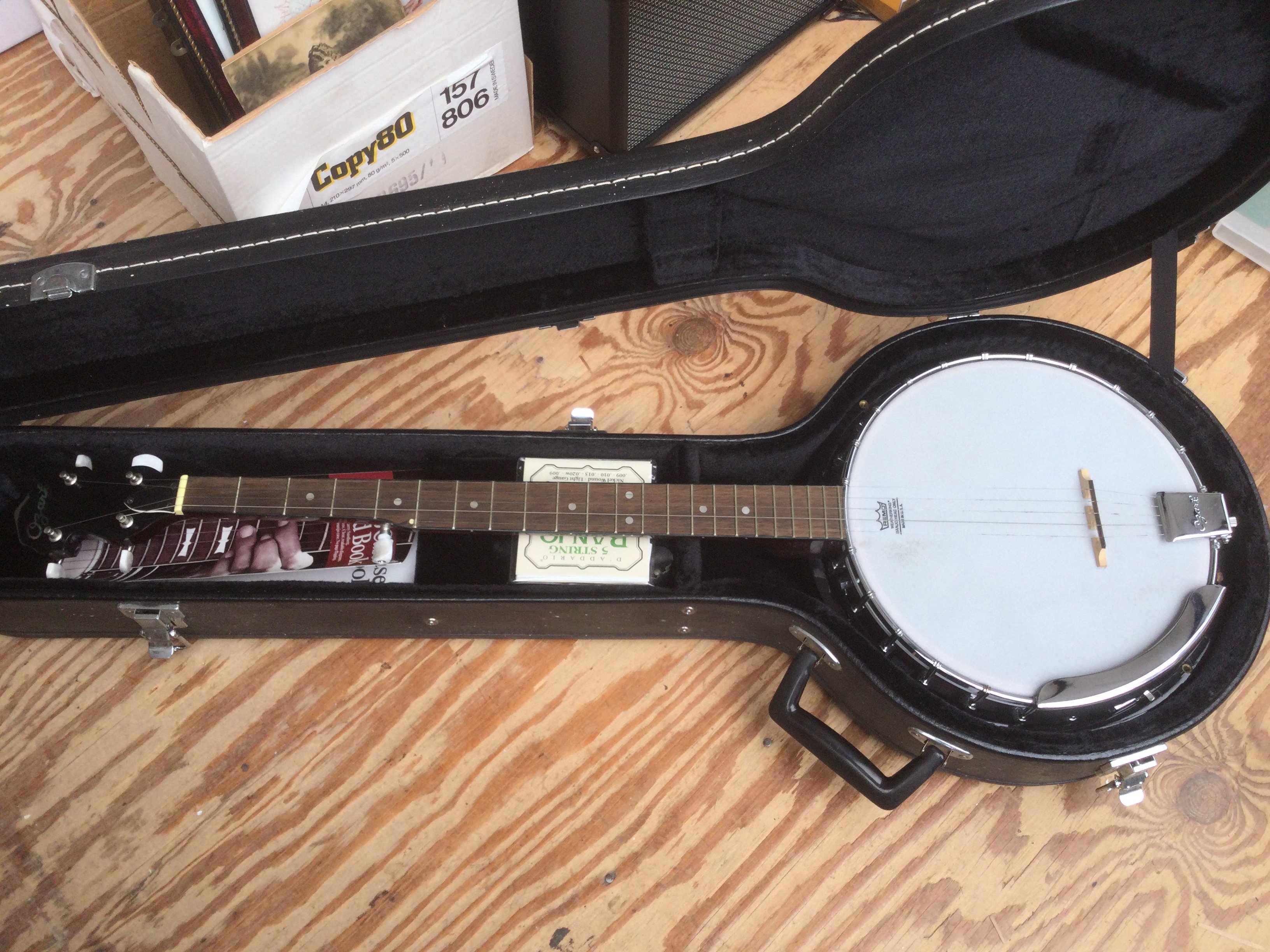 A cased Ozark banjo. Has been altered so it is now open backed but the original back cover is included.