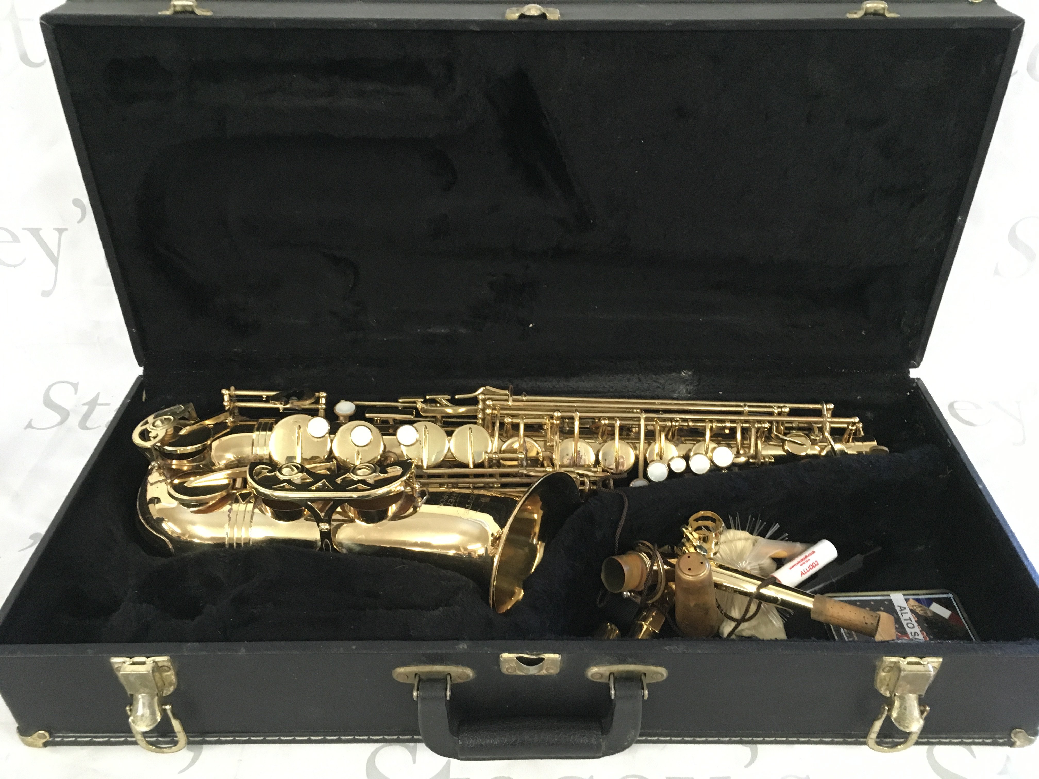 A cased Evette saxophone with accessories.