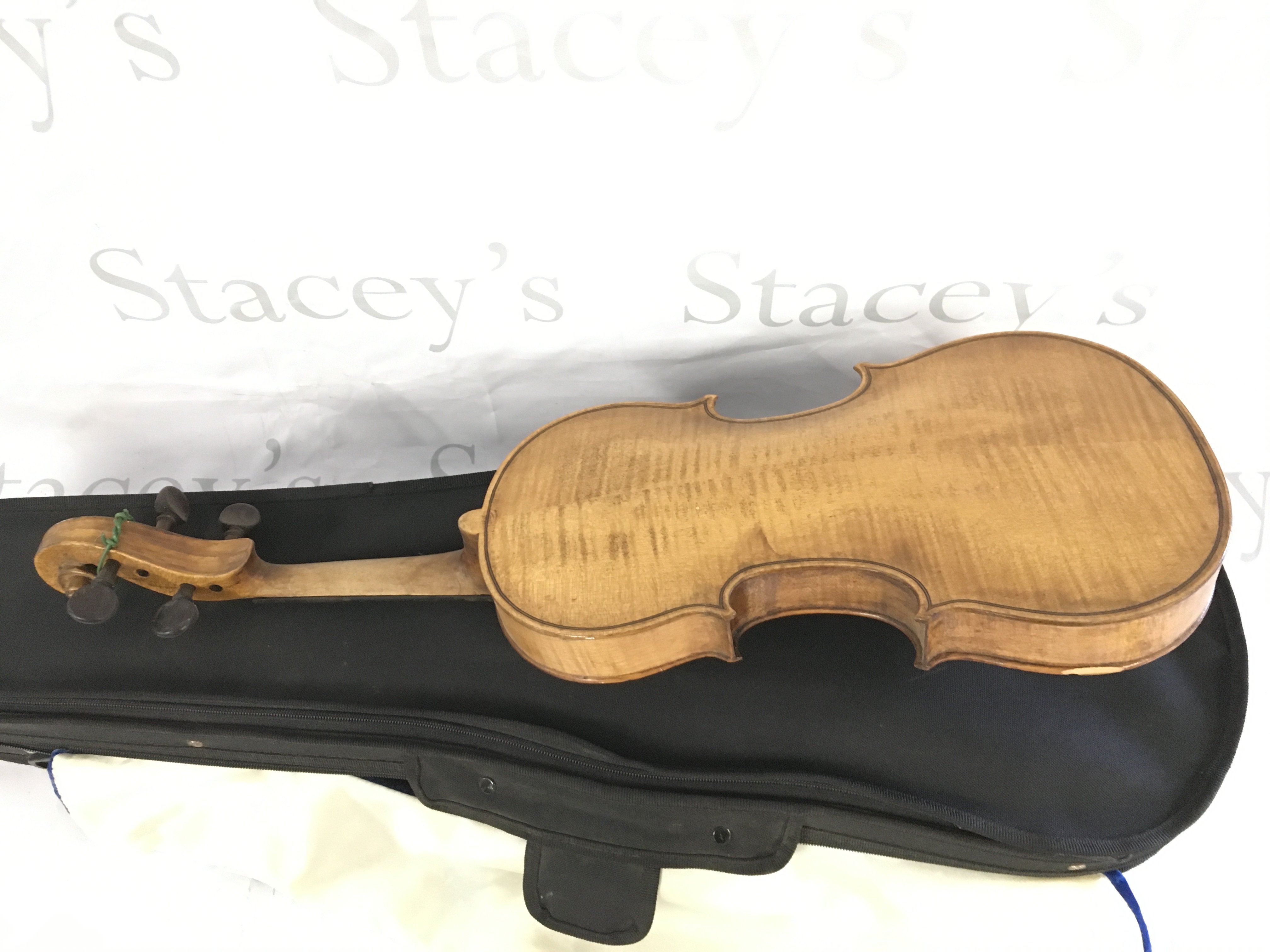 A cased violin and bow. The label inside the soundhole indicating it was manufactured on the Isle Of Wight.