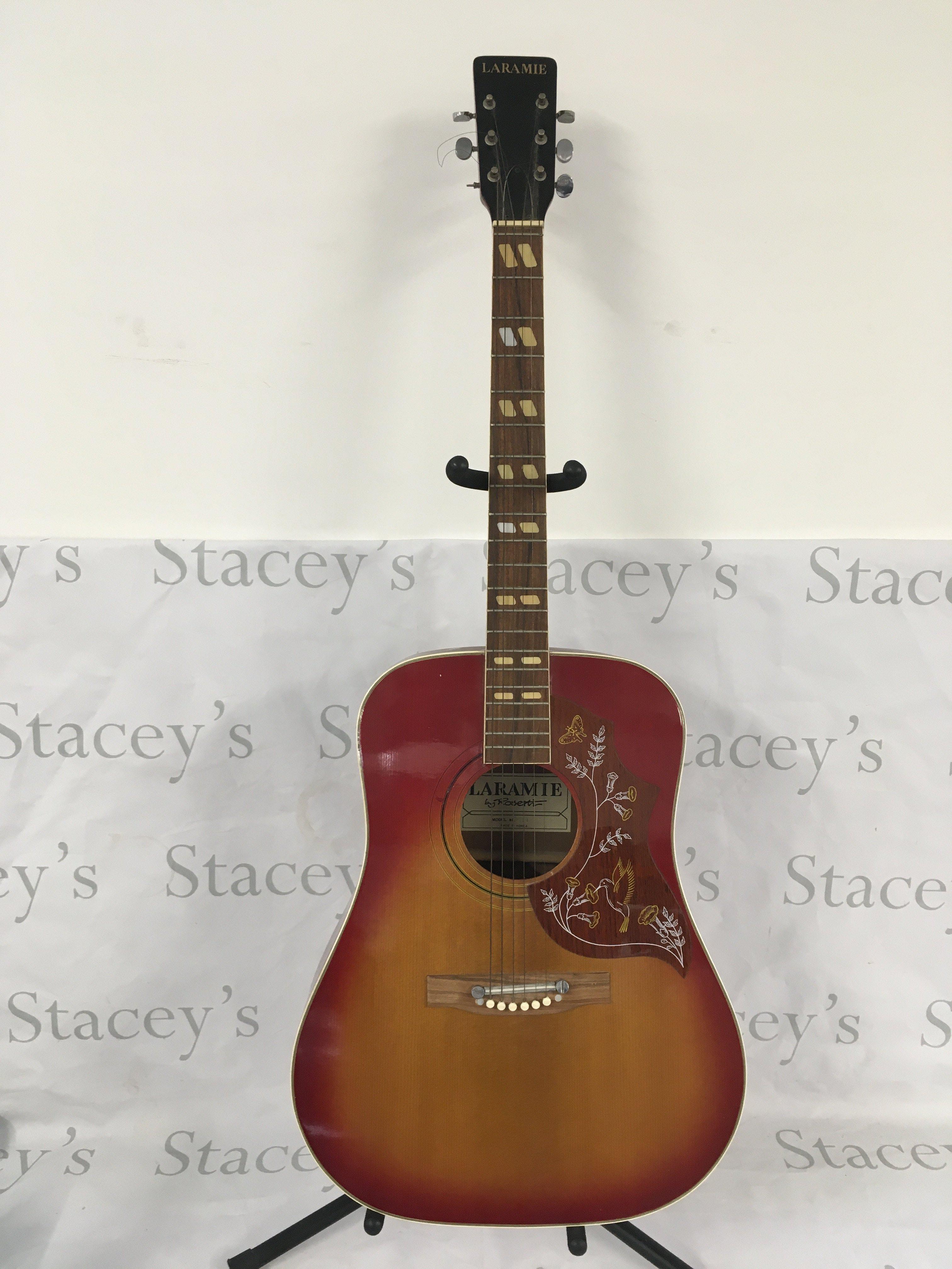 A Laramie Rosetti acoustic guitar with stand. No case.