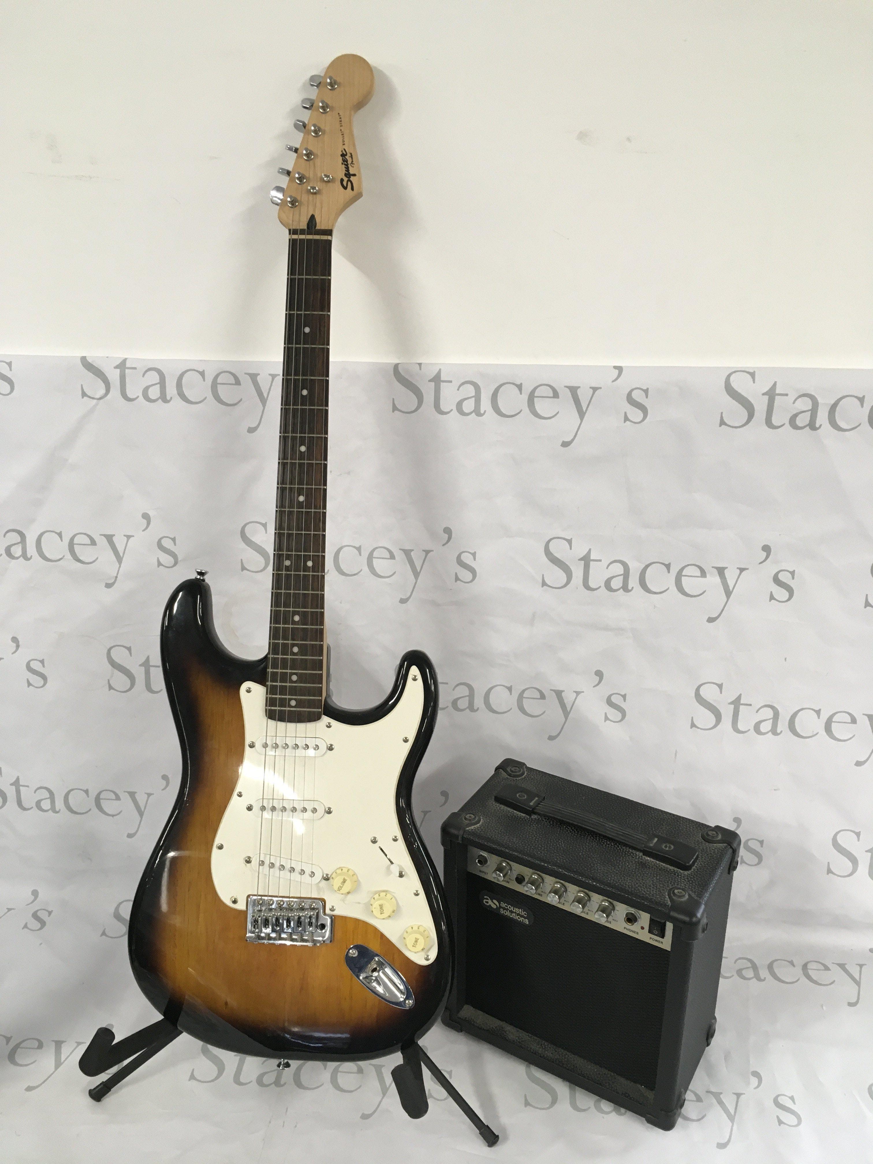 A Fender Squier Bullet Stratocaster with stand, soft case and practice amp (3).