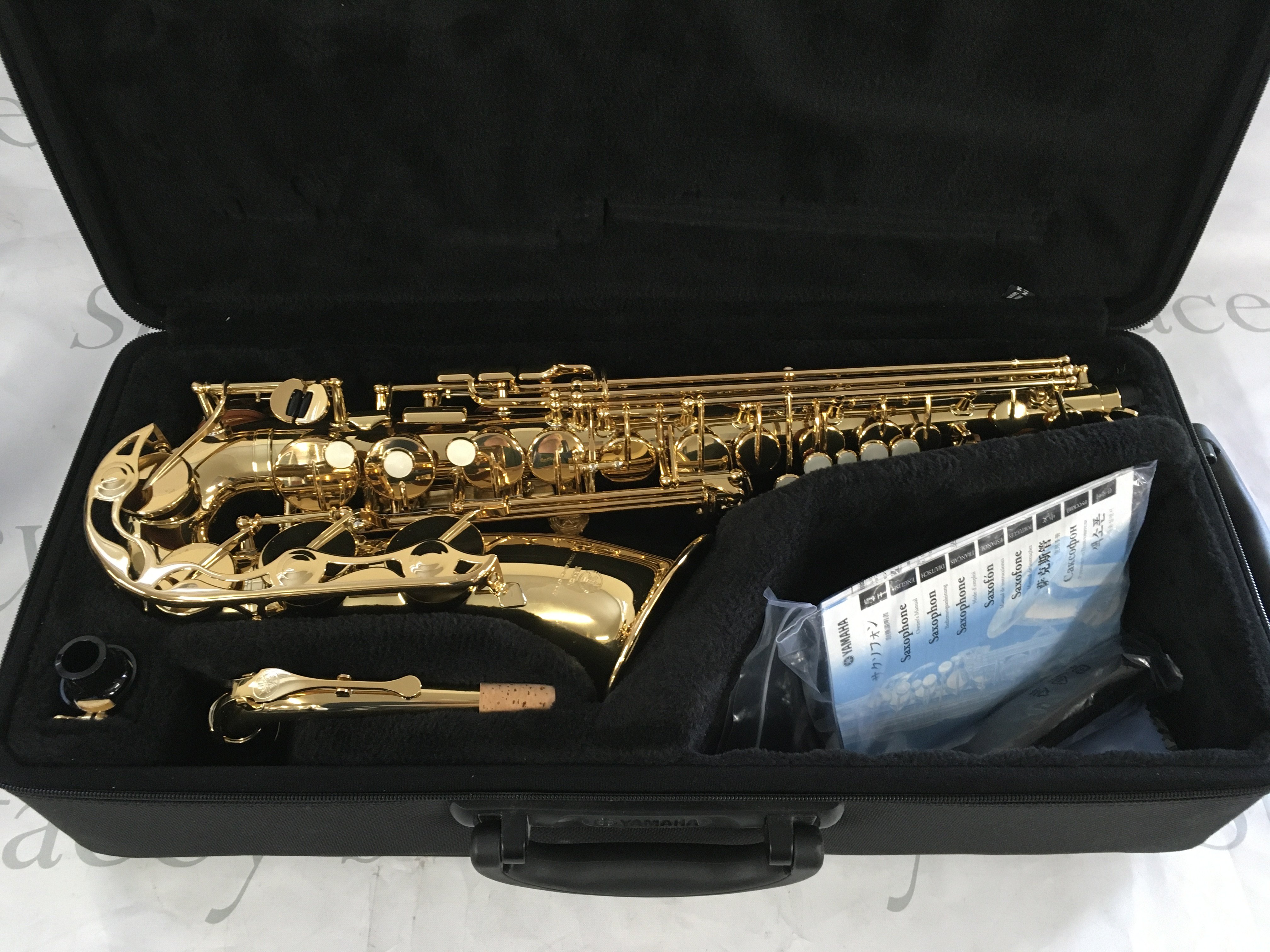 A cased Yamaha saxophone with accessories.