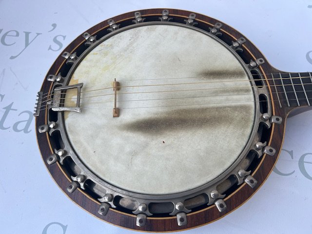 A 1930's Windsor Popular Model 5 6 string banjo. In good overall condition and with playwear consistent with age and use. Comes with its original fitted faux croc skin case.