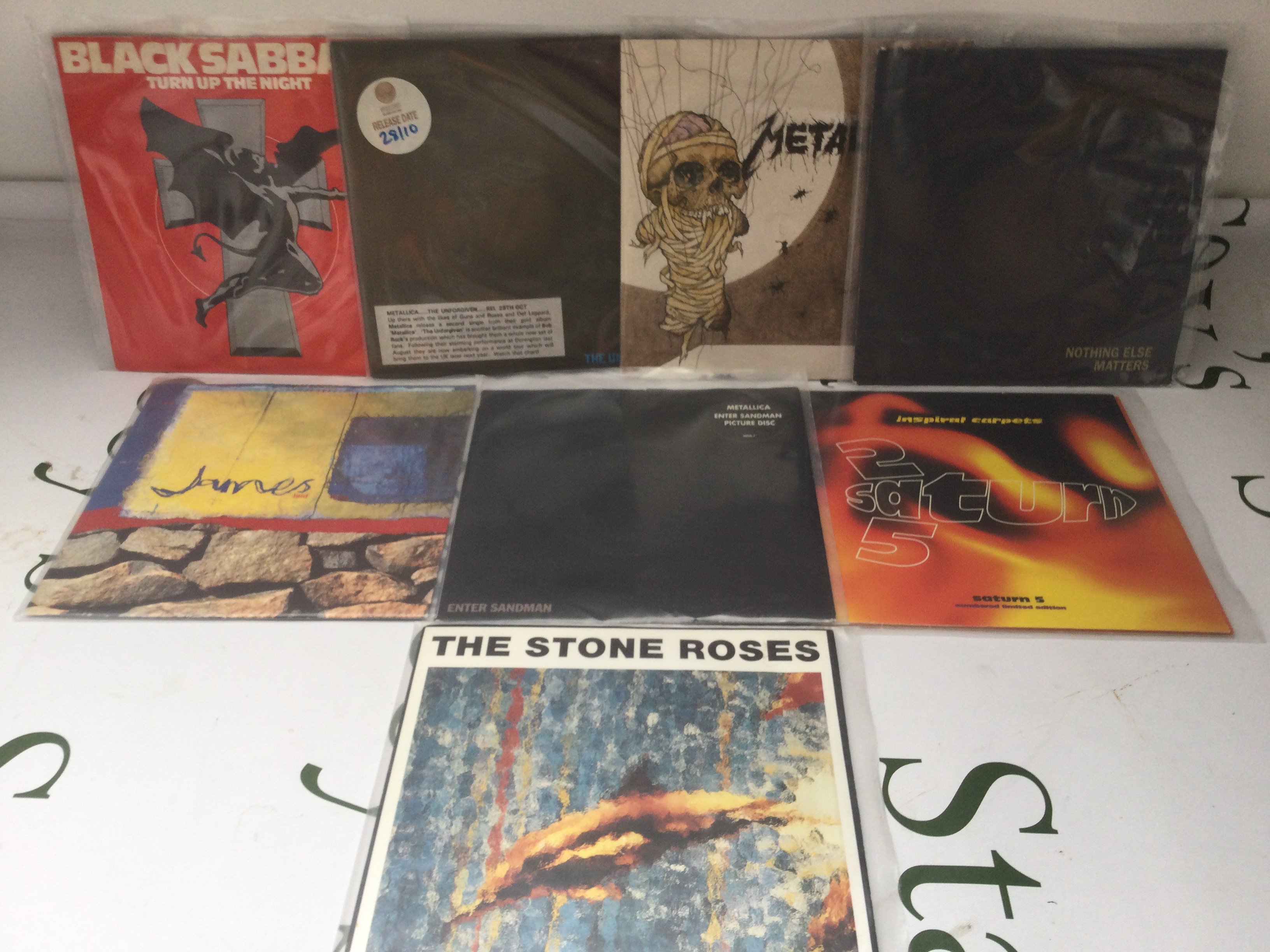 Eight rock and indie 7" singles comprising a Metallica promo disc, Stone Roses, James etc.