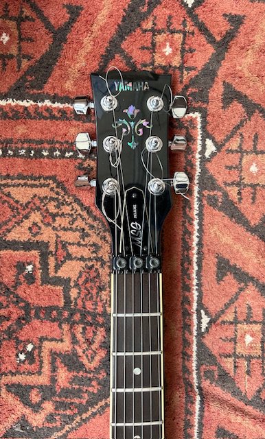 A 2000 Yamaha MSG Deluxe electric guitar with Yellow Flame Top HB Pickups and locking vibrato tremolo system. Good condition overall with one small varnish chip to neck rear.