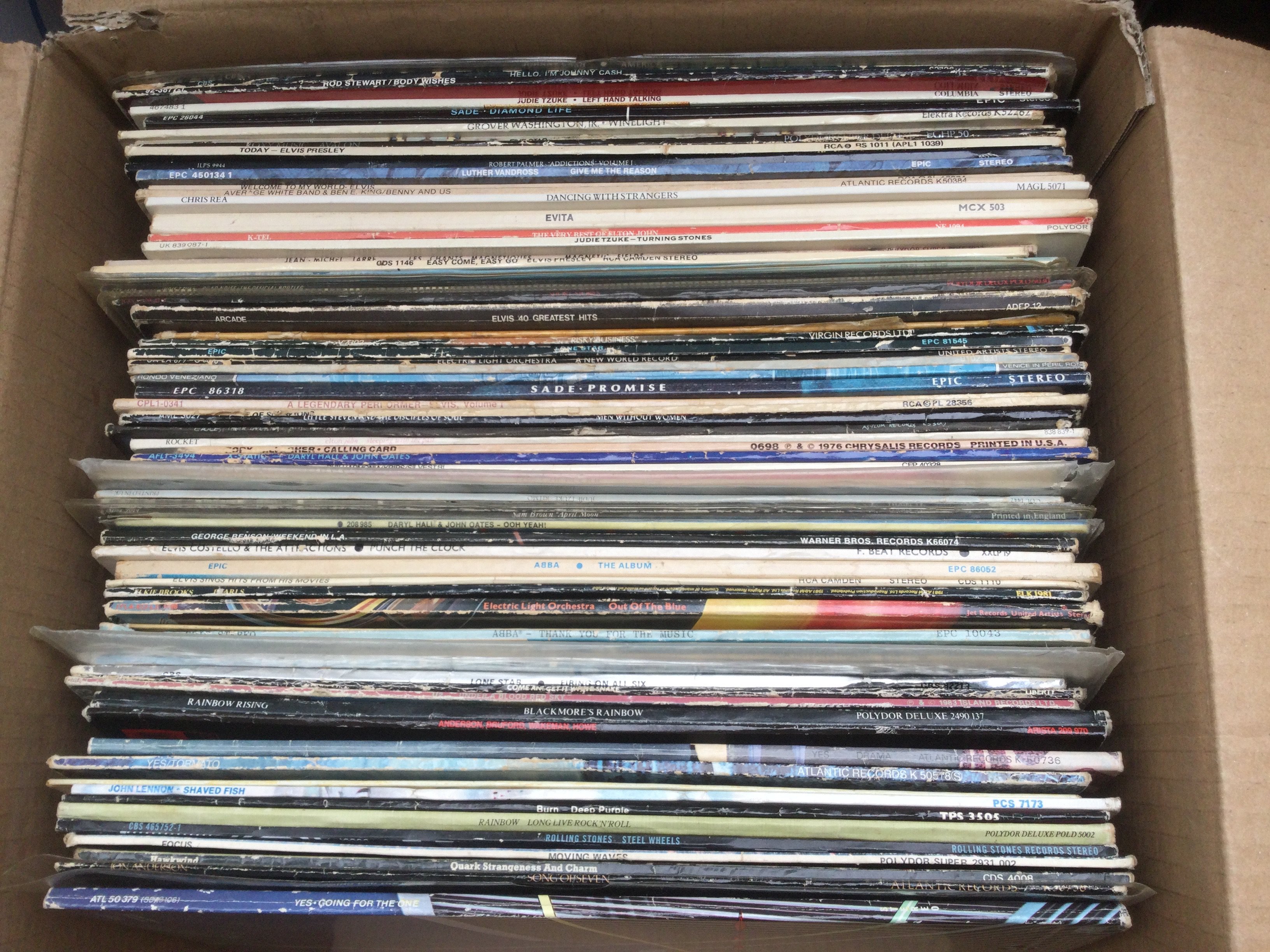 A box of LPs by various artists including Deep Purple, Rainbow, The Rolling Stones and others.