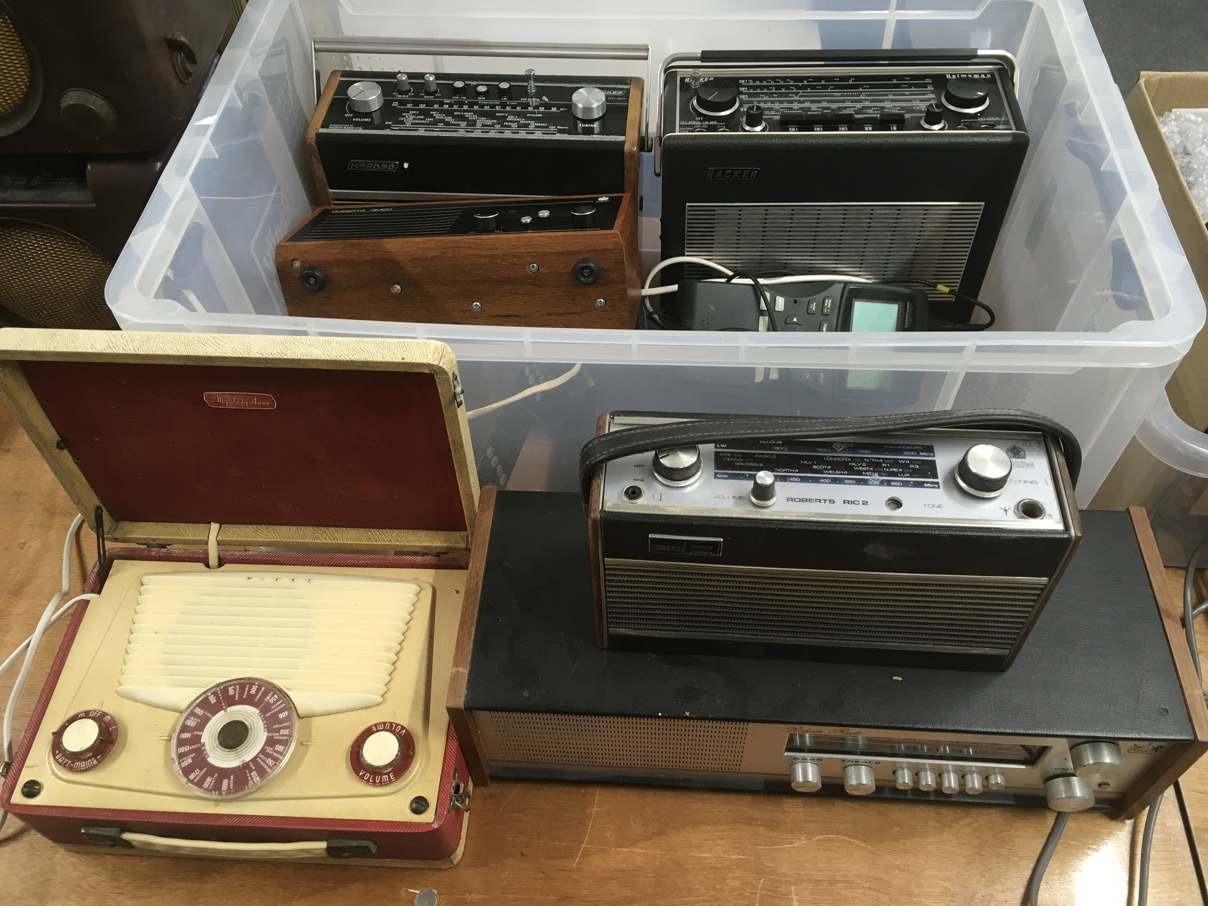 A collection of vintage radios, spare valves, circuit boards and other accessories.