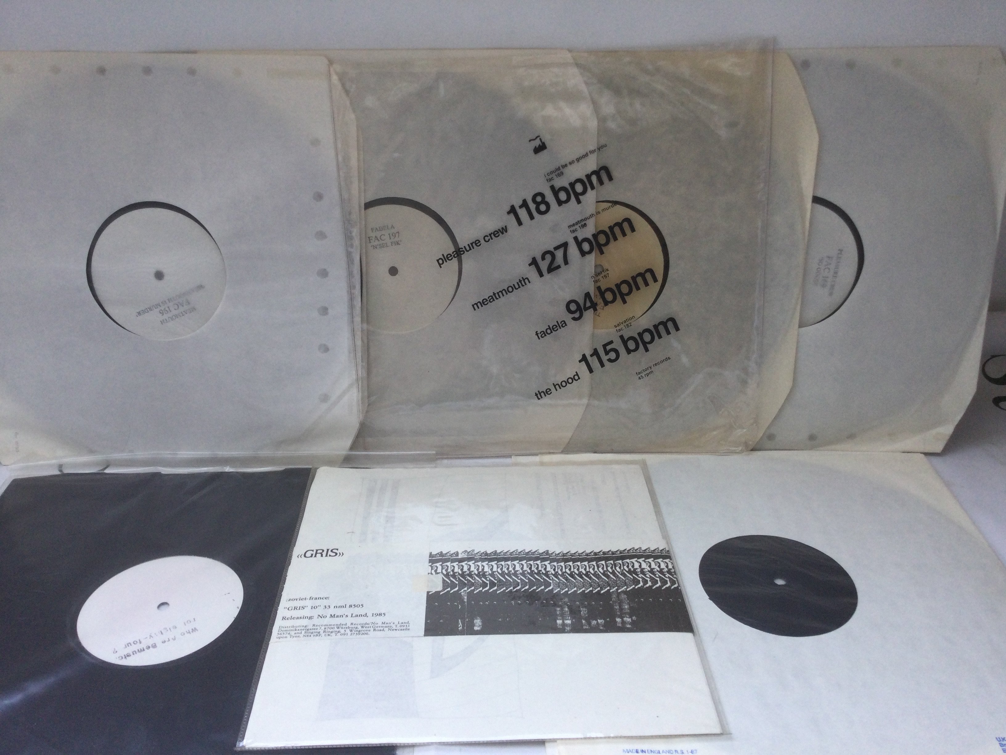 A small collection of white label records including a Factory Records four disc set.