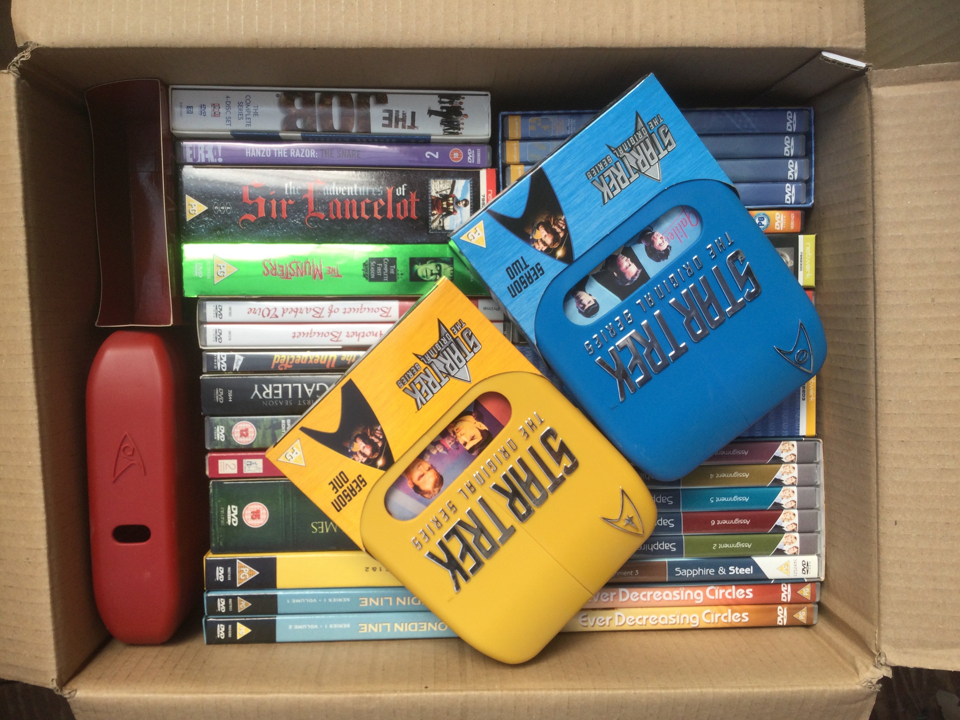 Four boxes of DVDs including various box sets.