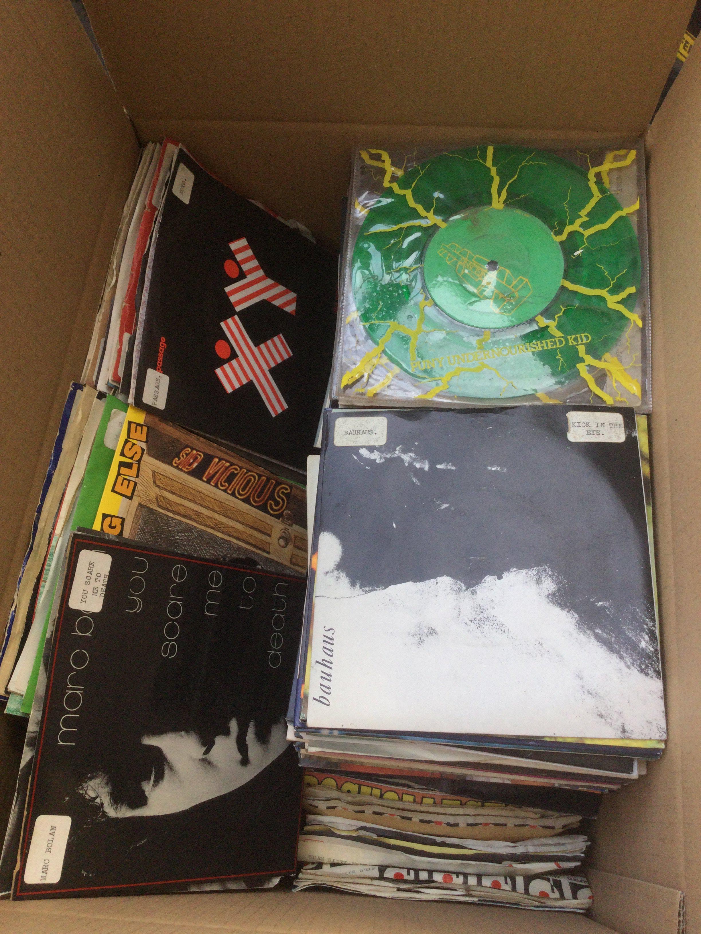 A box of 7" singles by various artists including Kate Bush, The Jam, Bauhaus, PiL and many more.