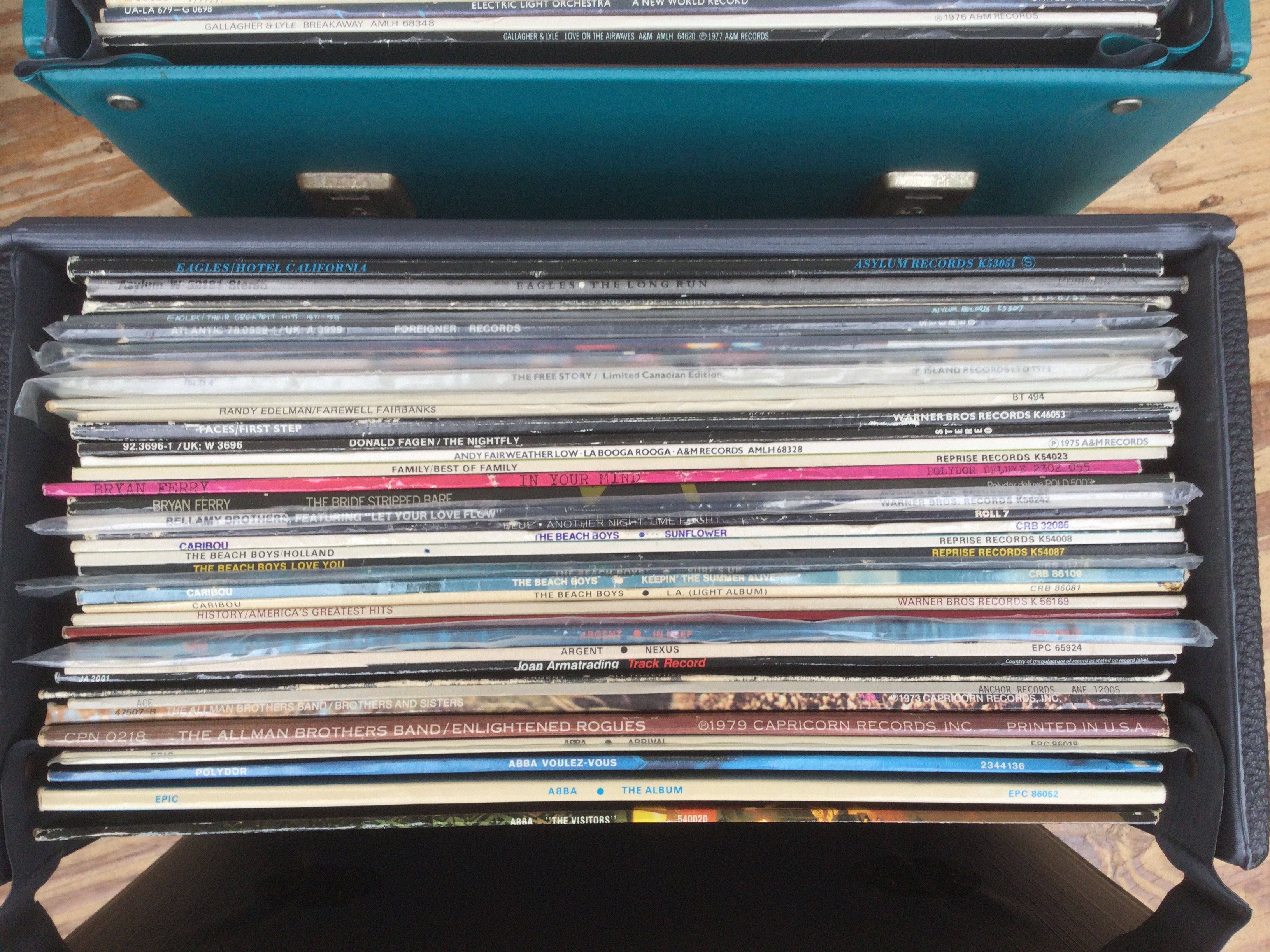 Three record cases of LP by various artists including Steely Dan, Thin Lizzy, Genesis and others.