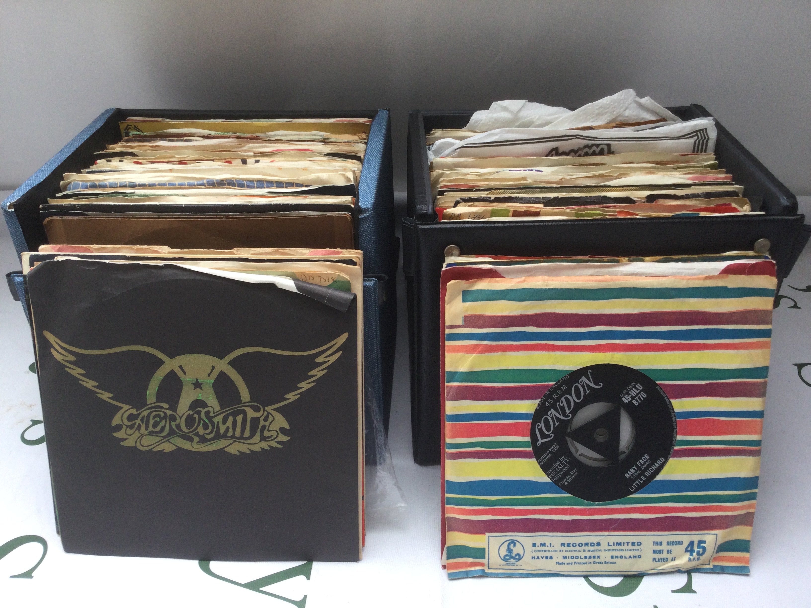 A box and two record cases of 7" singles by various artists including Elvis Presley, T Rex, Aerosmith and others.