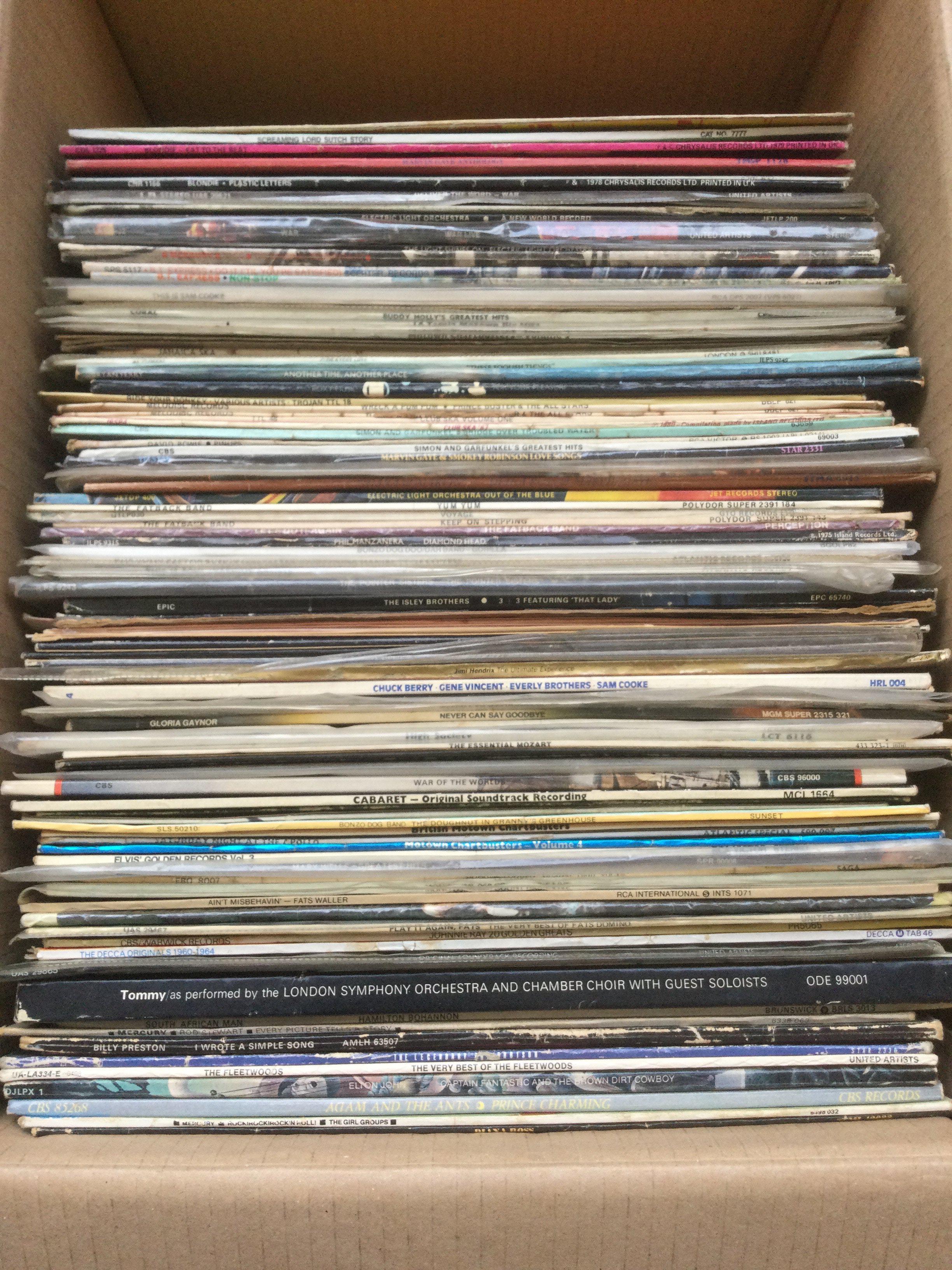 A box of LPs and 12" singles by various artists including David Bowie, Elton John, Prince Buster and others.