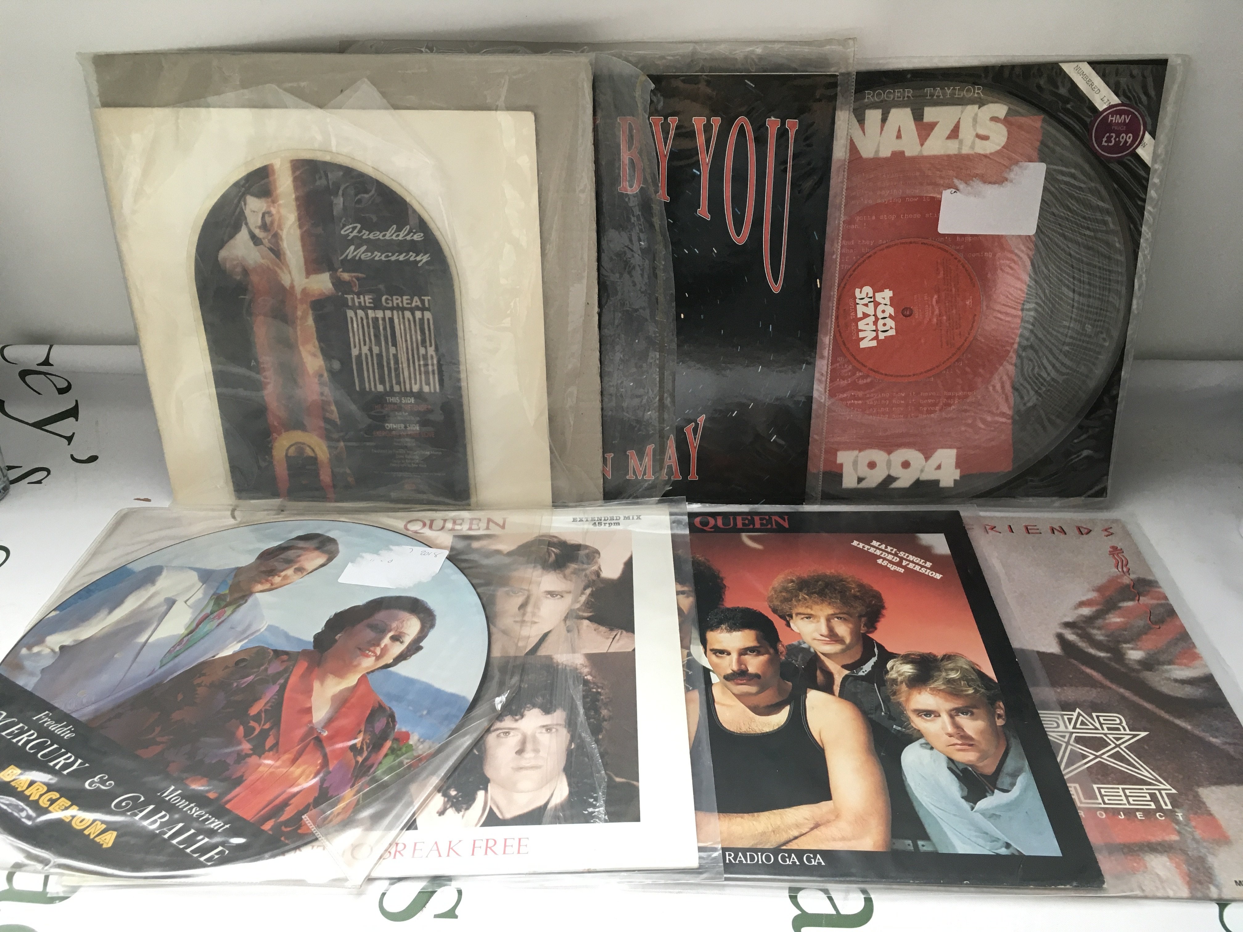Fifteen Queen and related 12" and 7" singles including a Great Pretender shaped disc, Barcelona picture disc and others.