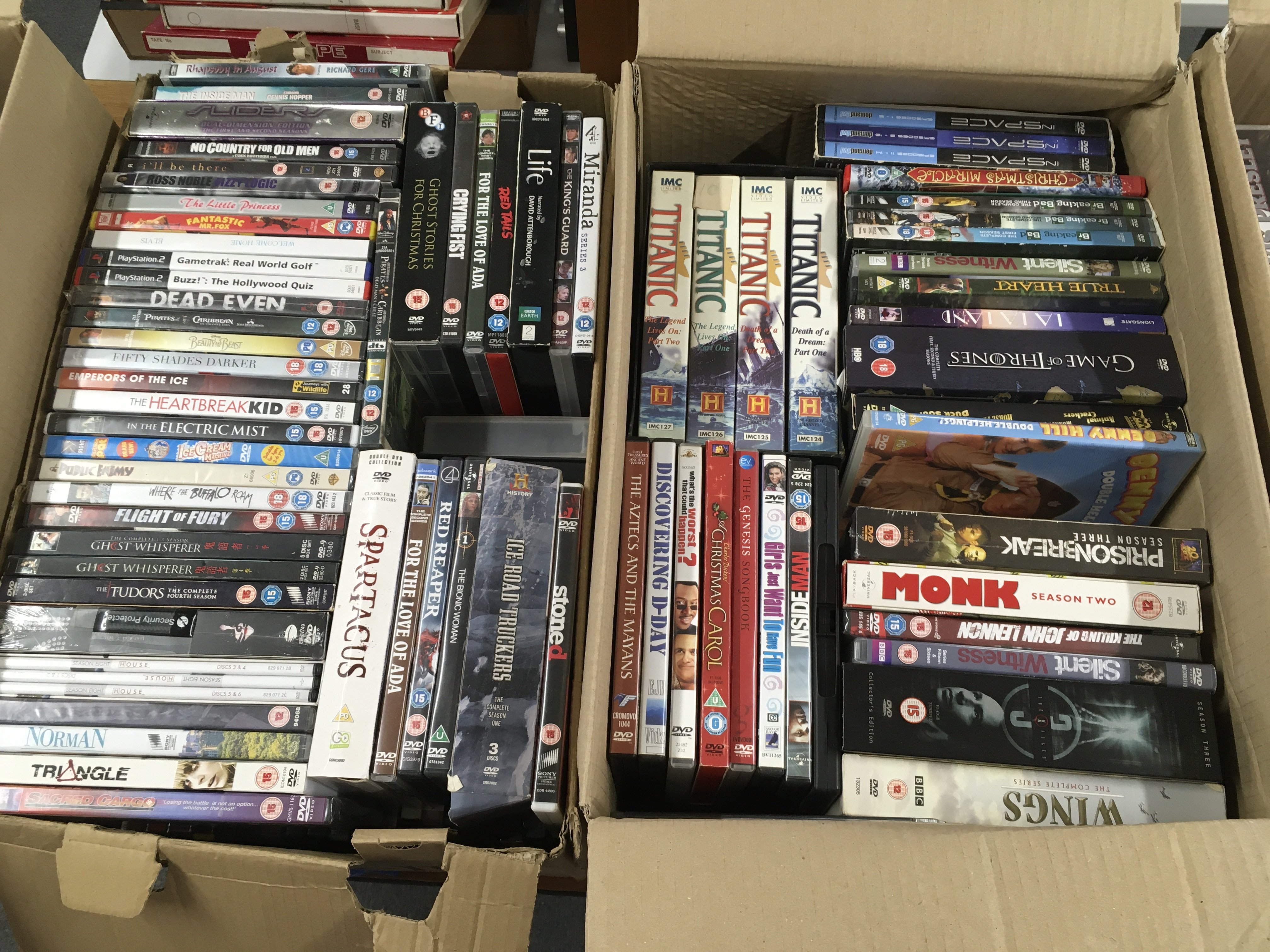Four boxes of DVDs comprising various films and TV series including some box sets.