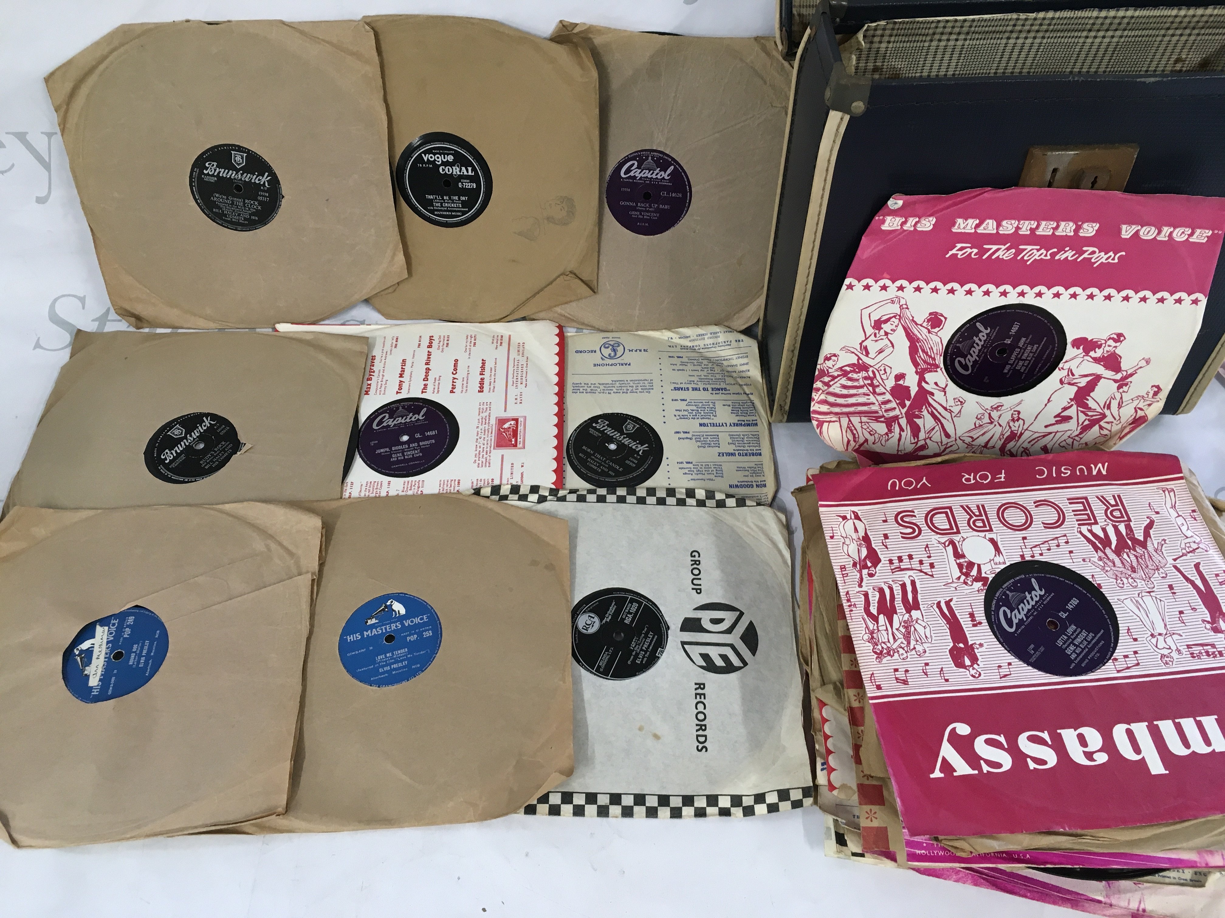 A box of records comprising some rock n roll 78s by various artists including Gene Vincent, Elvis Presley and others plus some LPs, 12" and 7" singles by various artists.