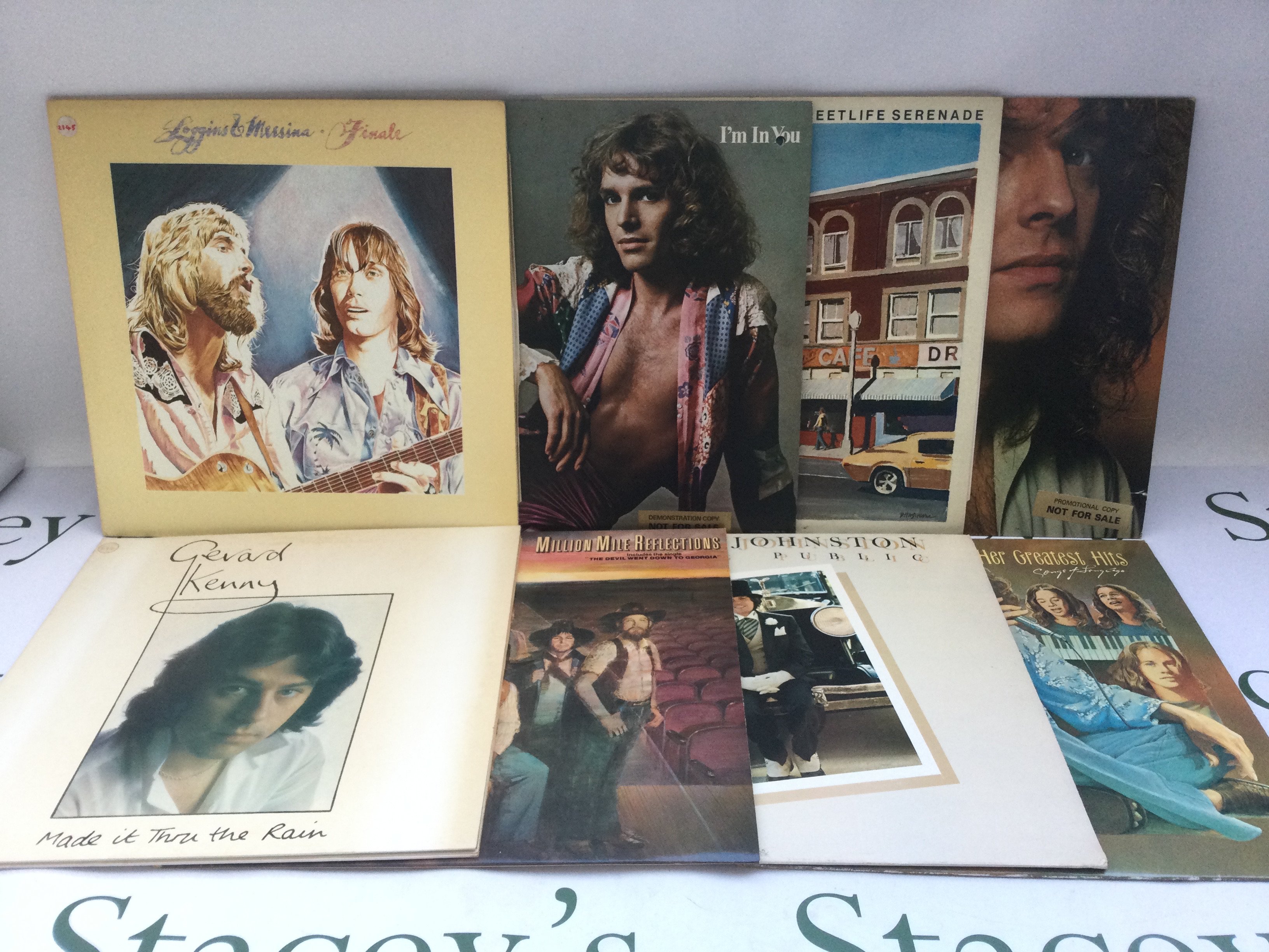 Two bags containing 22 promo copy LPs and 12" singles by various artists including Bruce Springsteen, Loggins & Messina, Carole King and others.