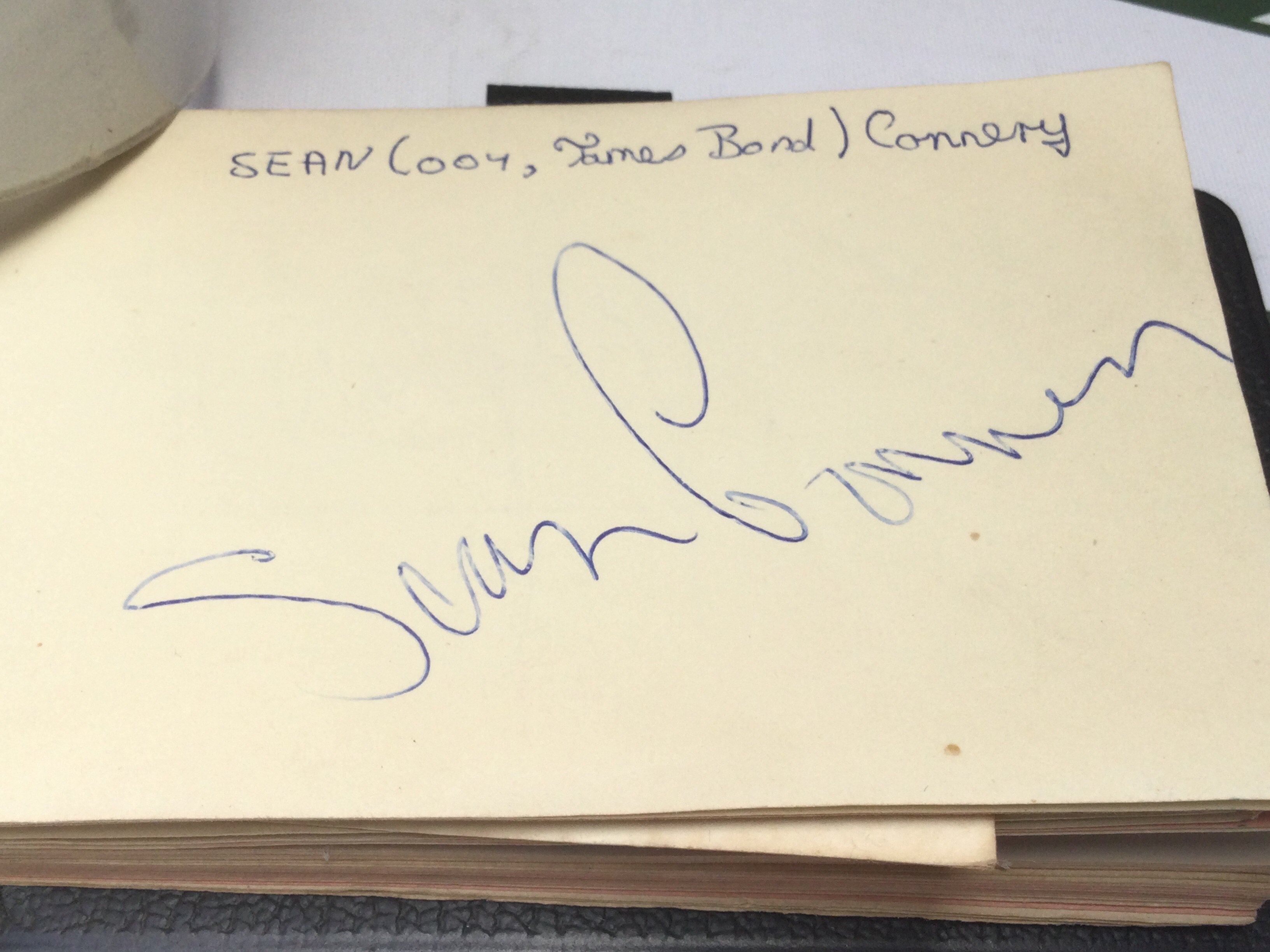 An autograph booklet containing various signatures including Sean Connery, Georgie Fame, Stirling Moss and others.